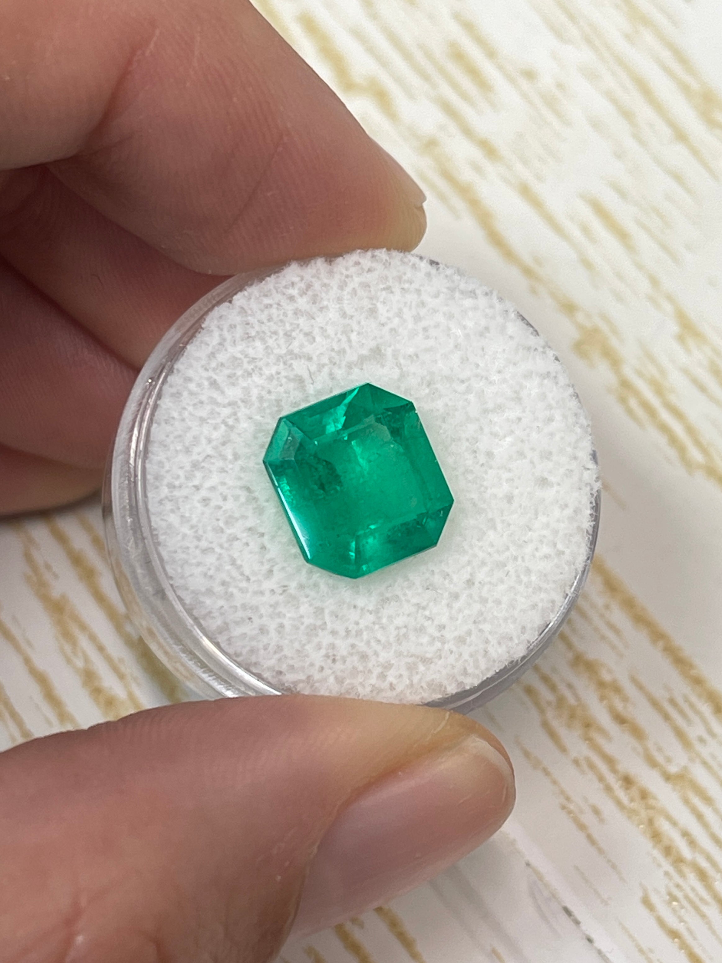 Vivid yellowish 4.12-carat Colombian emerald loose gemstone in an emerald cut, showcasing rich color and clarity.