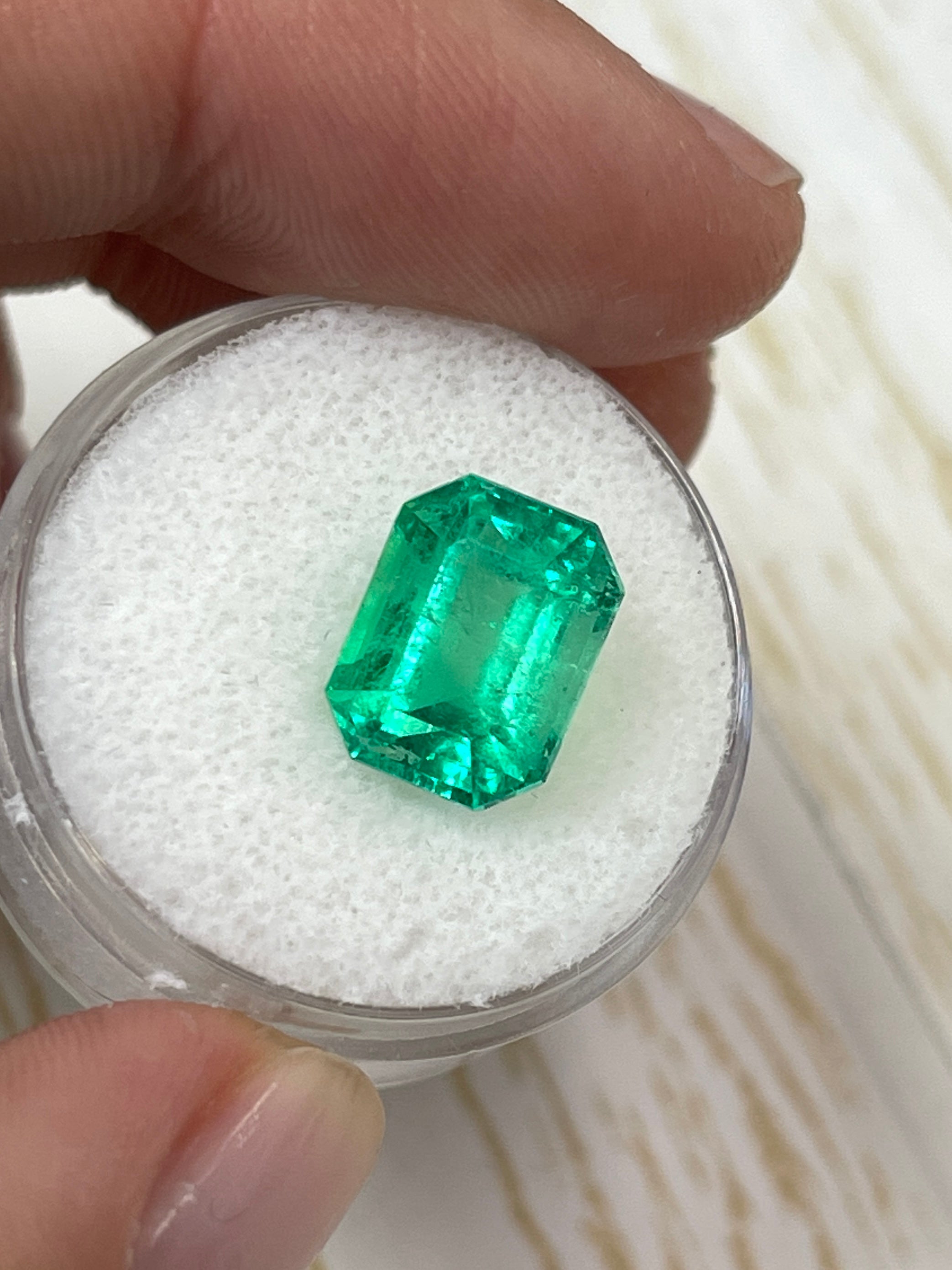 4.70 carat yellowish green natural Colombian emerald in classic emerald cut, loose gemstone with vibrant color and clarity.