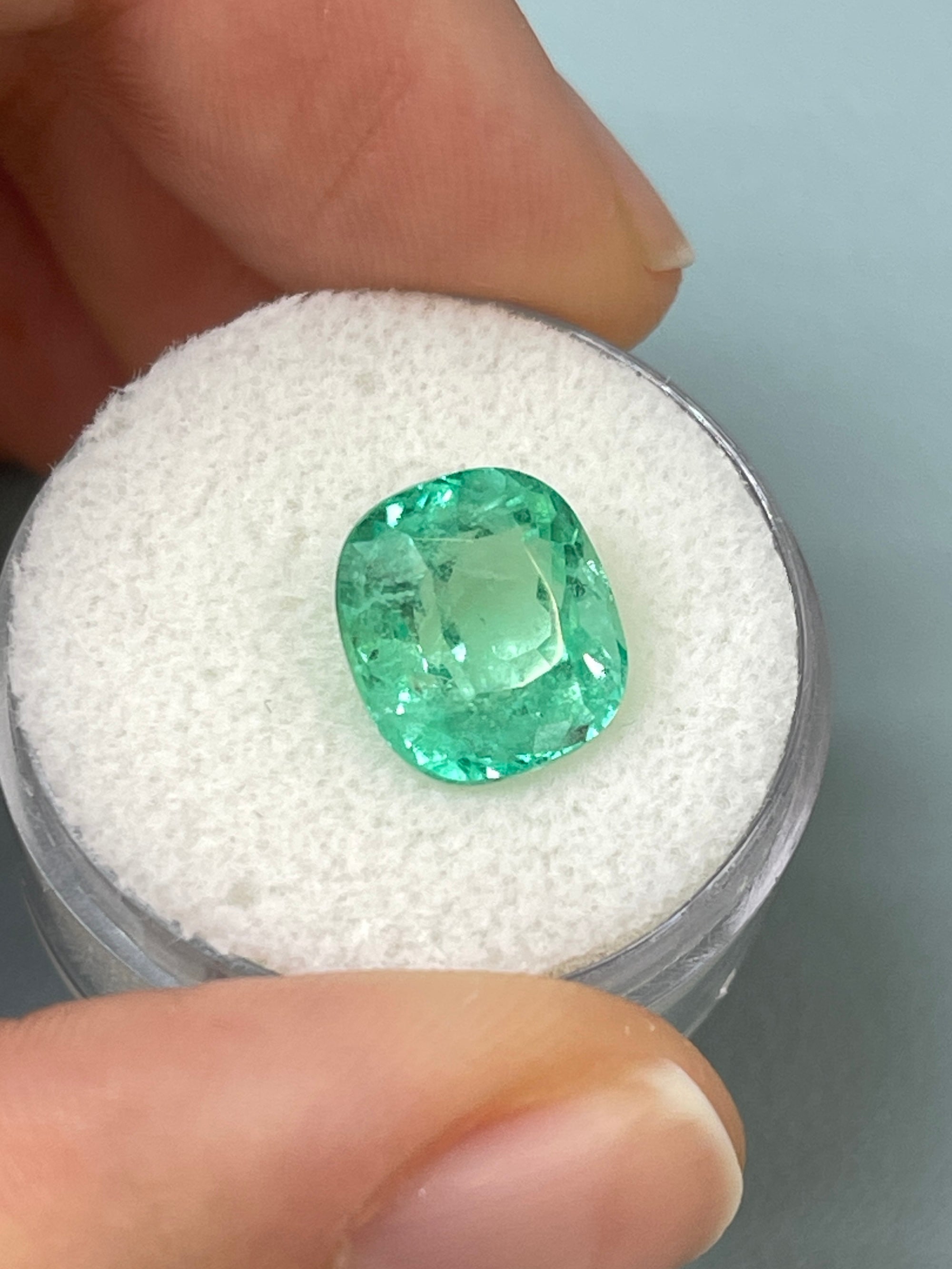 Light green 4.71 carat Colombian emerald loose cushion cut from JR Colombian Emeralds, natural gemstone with vibrant color.