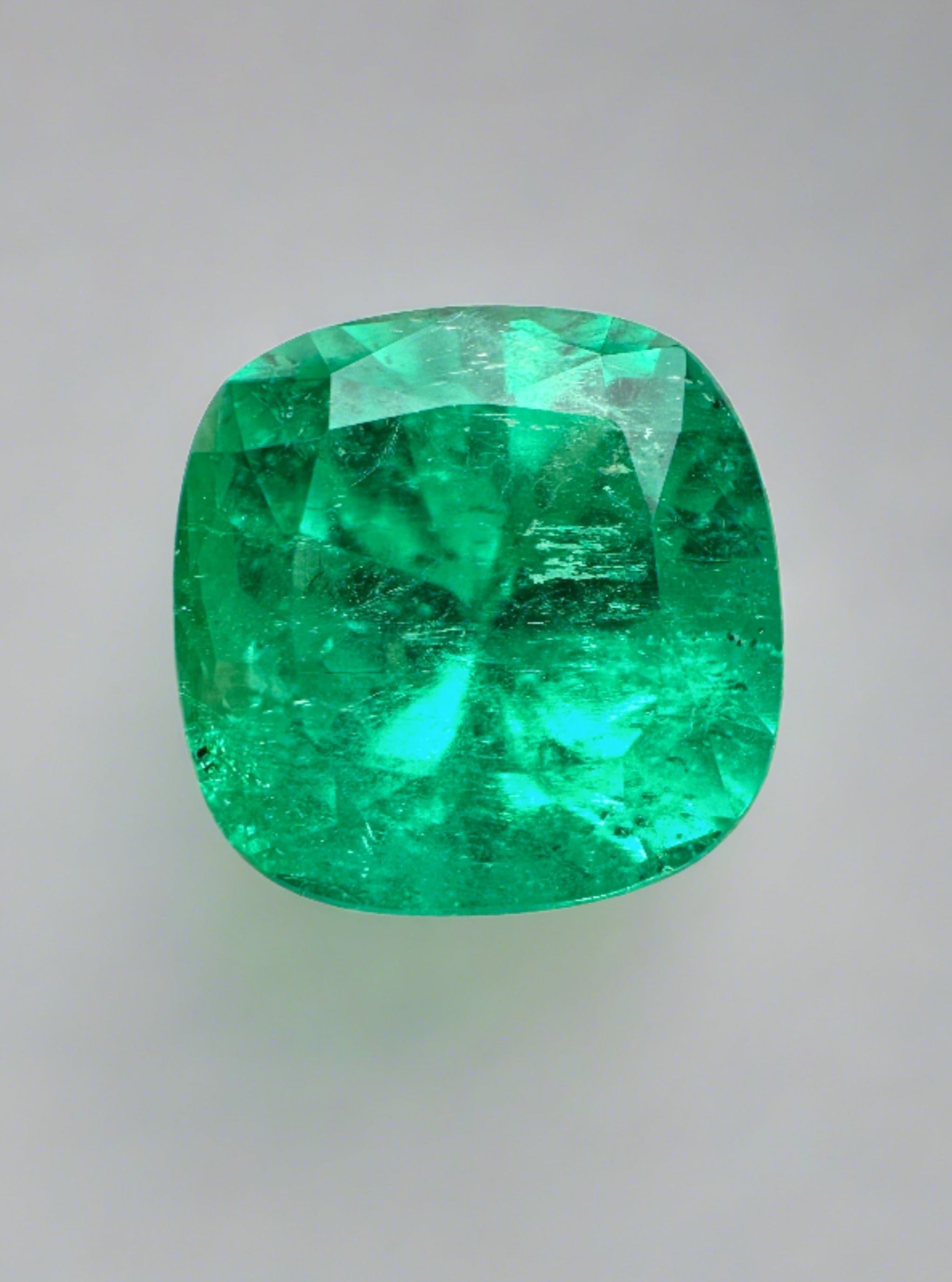 Bright green 4.72 carat cushion cut natural Colombian emerald, showcasing its vibrant color and clarity.