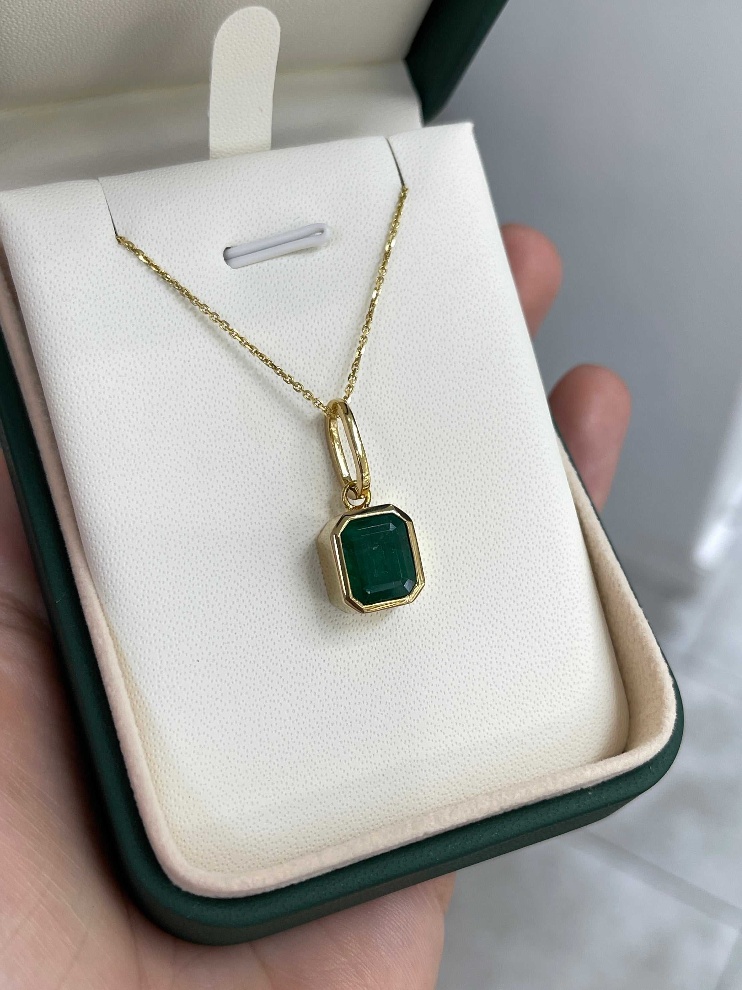 Dark green Zambian emerald necklace with 4.98 carat bezel-set emerald in 14K gold, featuring a detailed jewelry design.