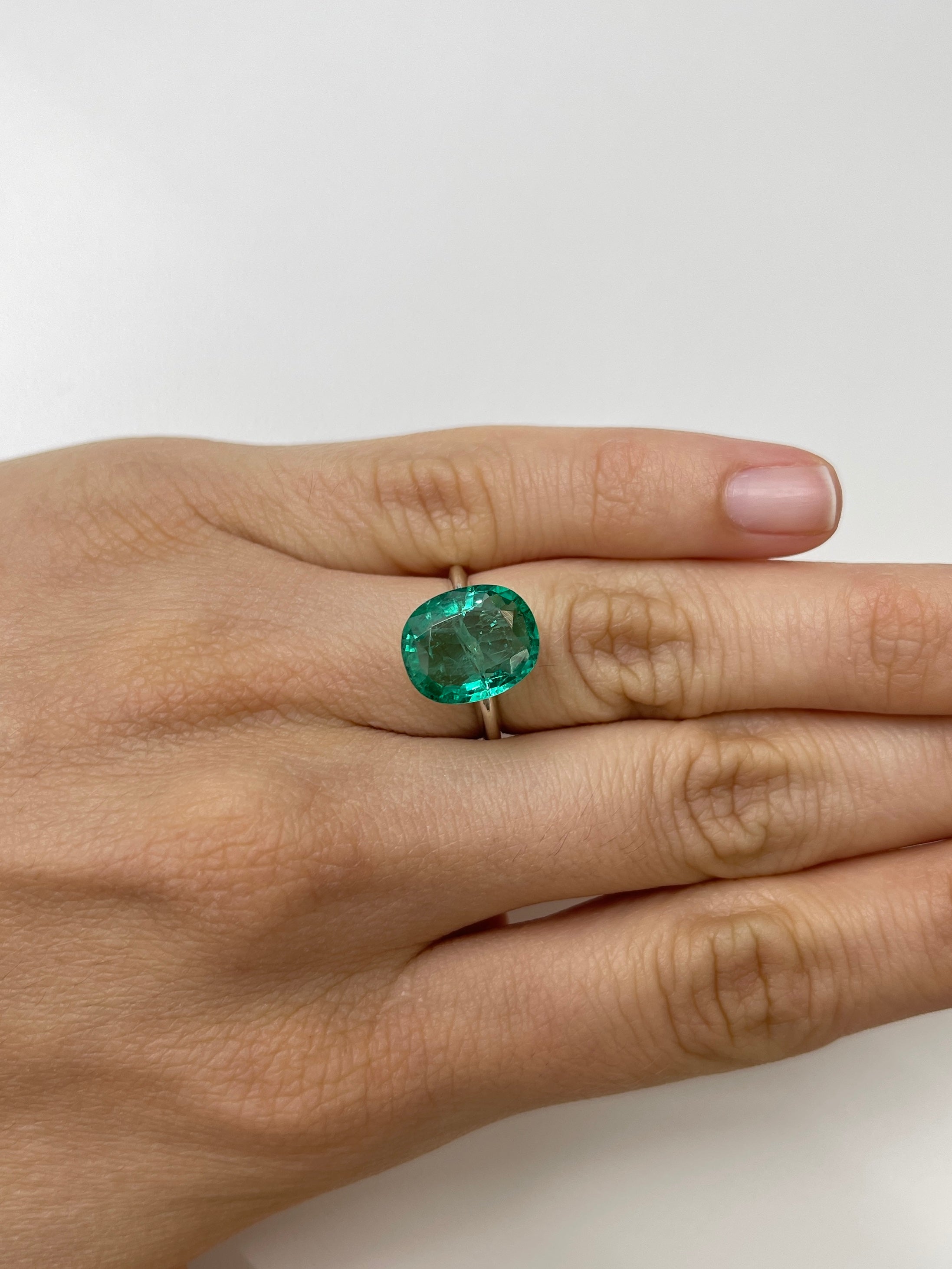 5.09 carat natural Zambian emerald loose gemstone with hybrid cushion and oval cut, showcasing a bubbly, vibrant green hue.
