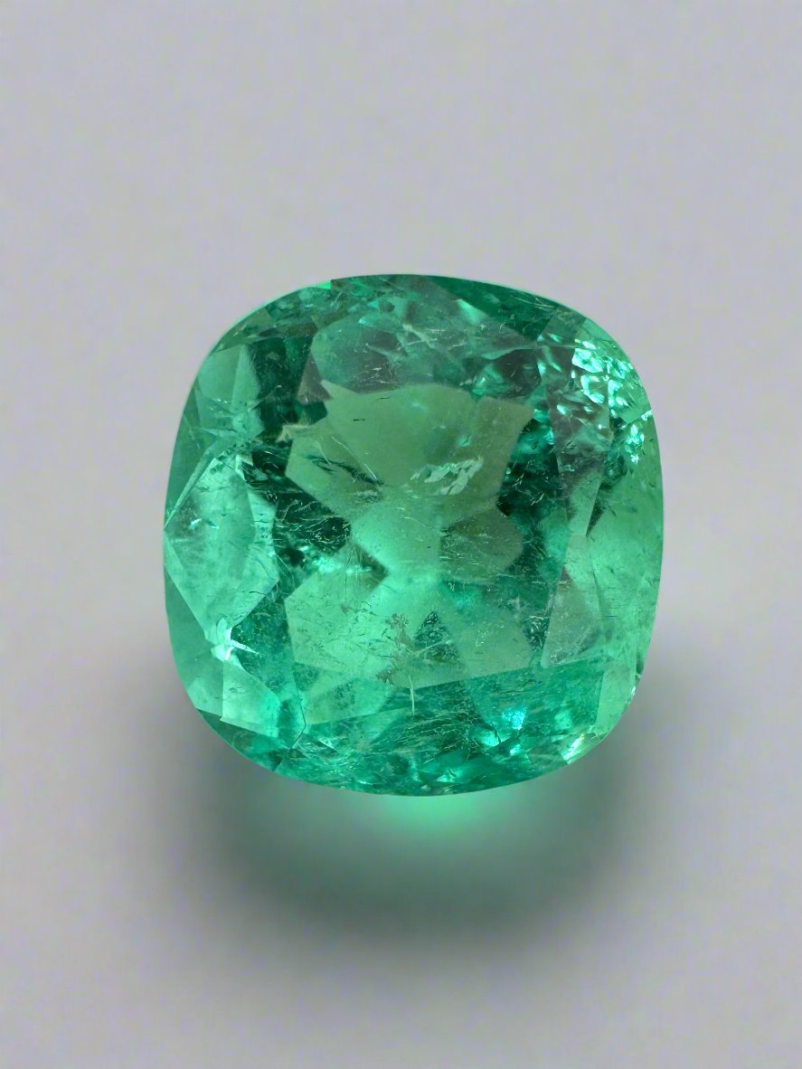Bright bluish green 5.20 carat natural Colombian emerald in cushion cut, shown loose with vibrant color and clarity.