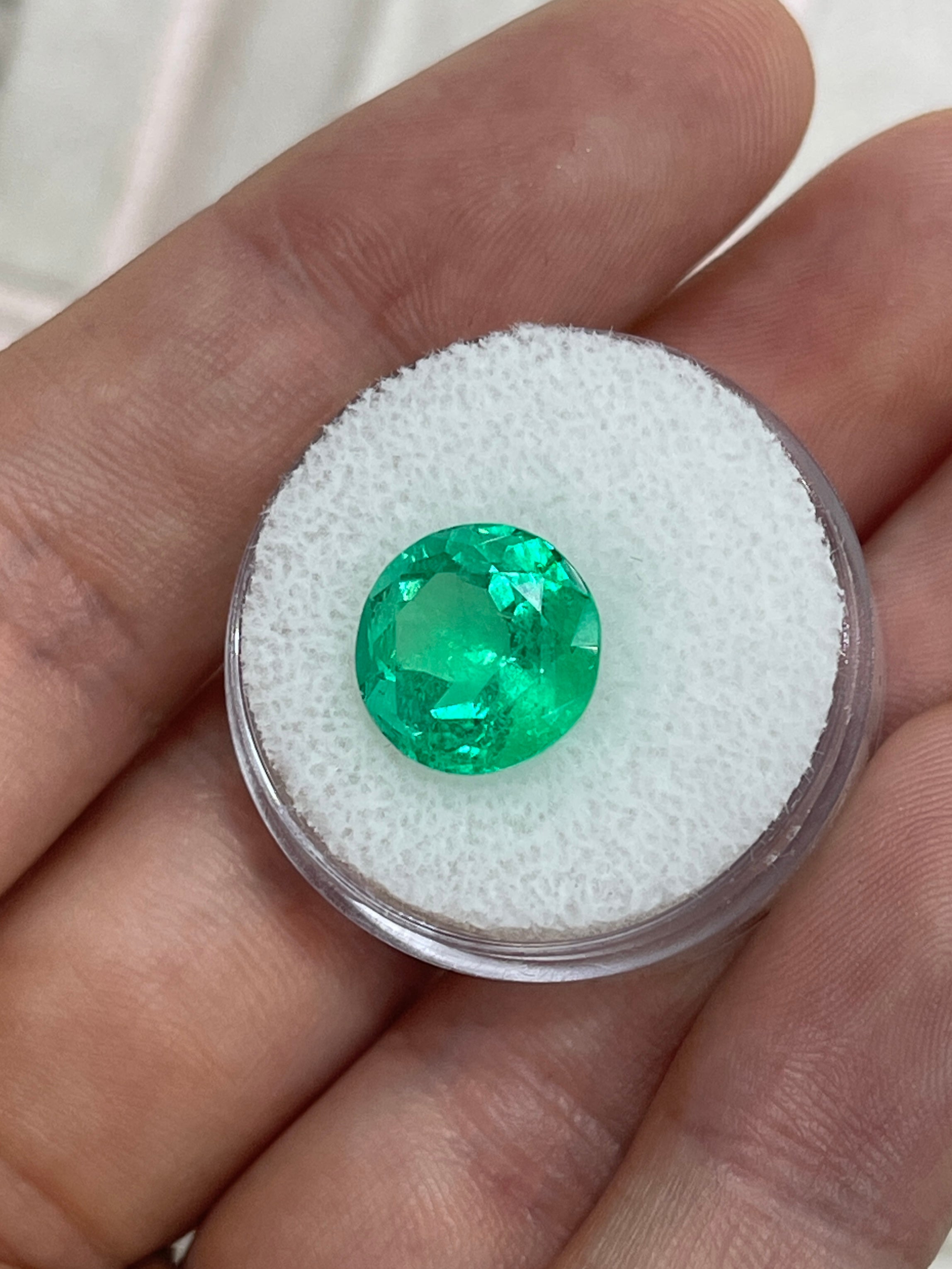 Vibrant 5.48 carat round Colombian emerald with natural green color, showcasing gemmy clarity and smooth cut.