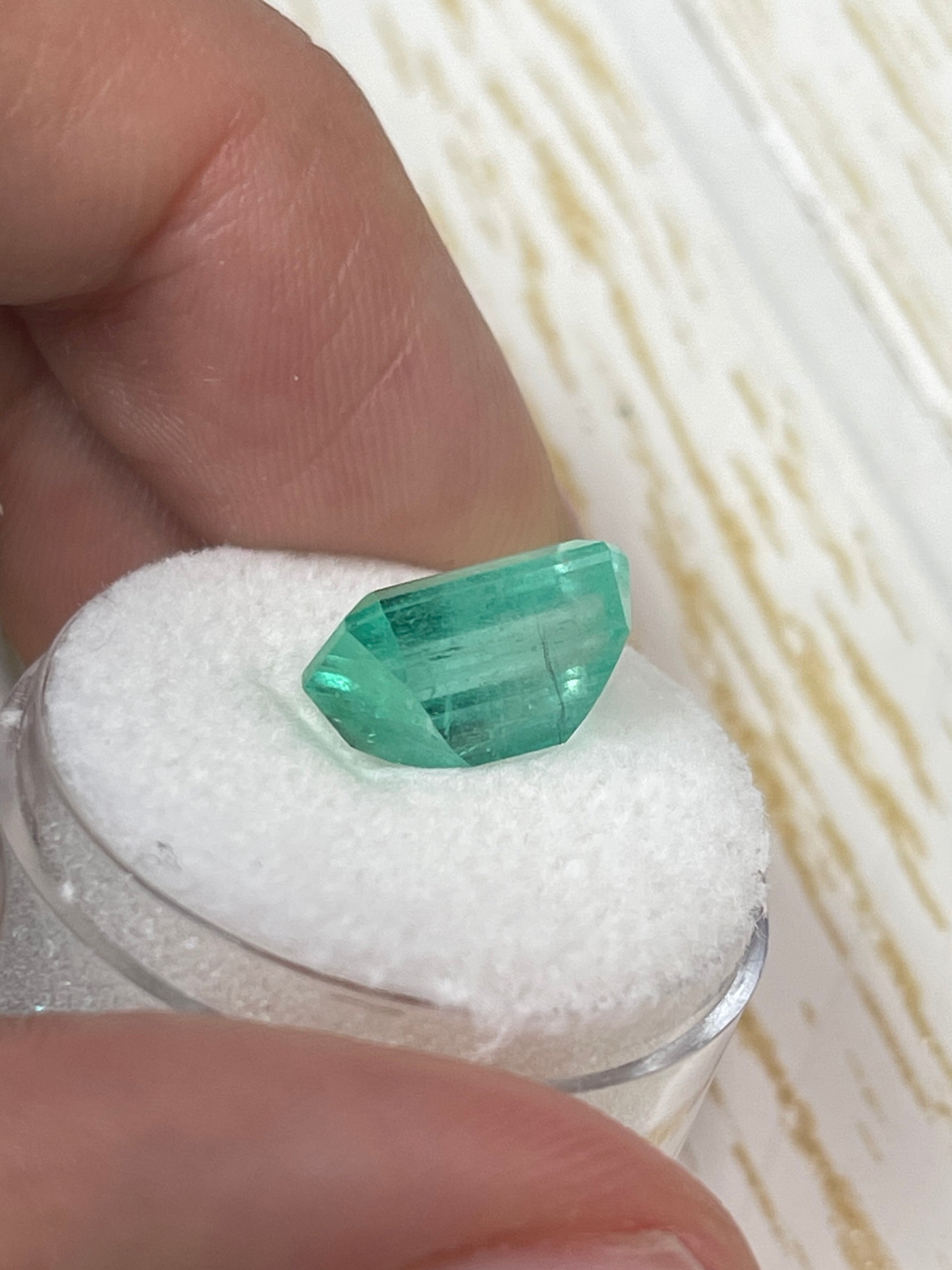 Loose 5.55 carat pastel green Colombian emerald in an emerald cut, showcasing natural color and clarity.