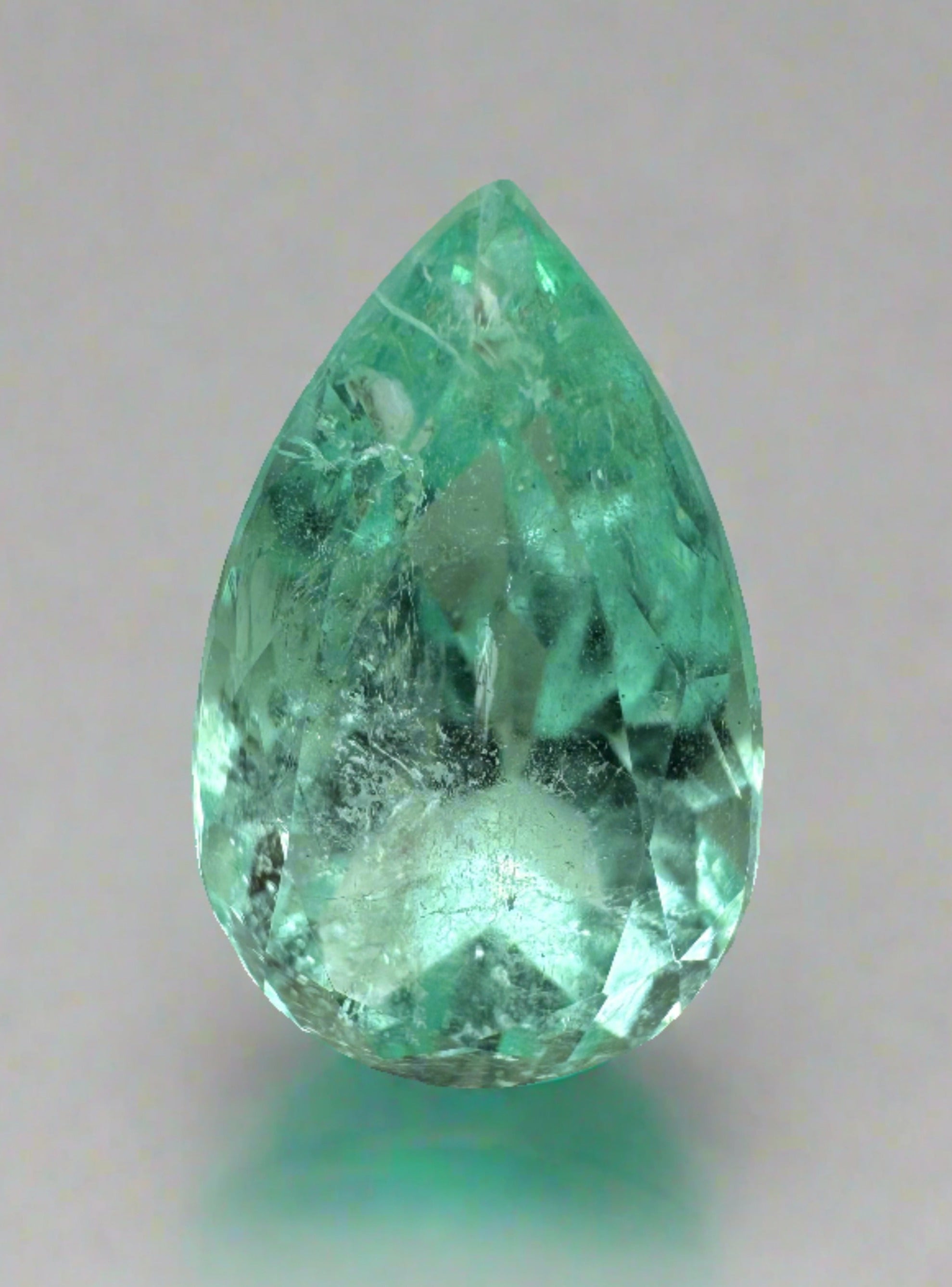 Light green 5.57 carat natural Colombian emerald in pear cut, showcasing its glow and clarity from JR Colombian Emeralds.