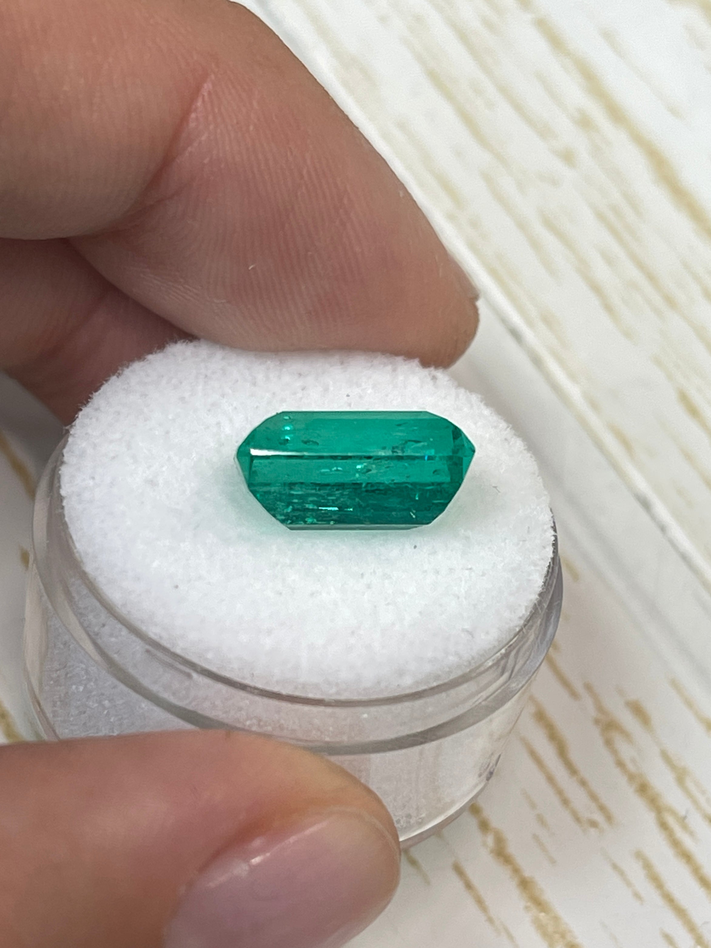 Natural 5.63 carat 13x8mm VS bluish-green Colombian emerald loose gemstone in an emerald cut, showcasing vivid color and clarity.