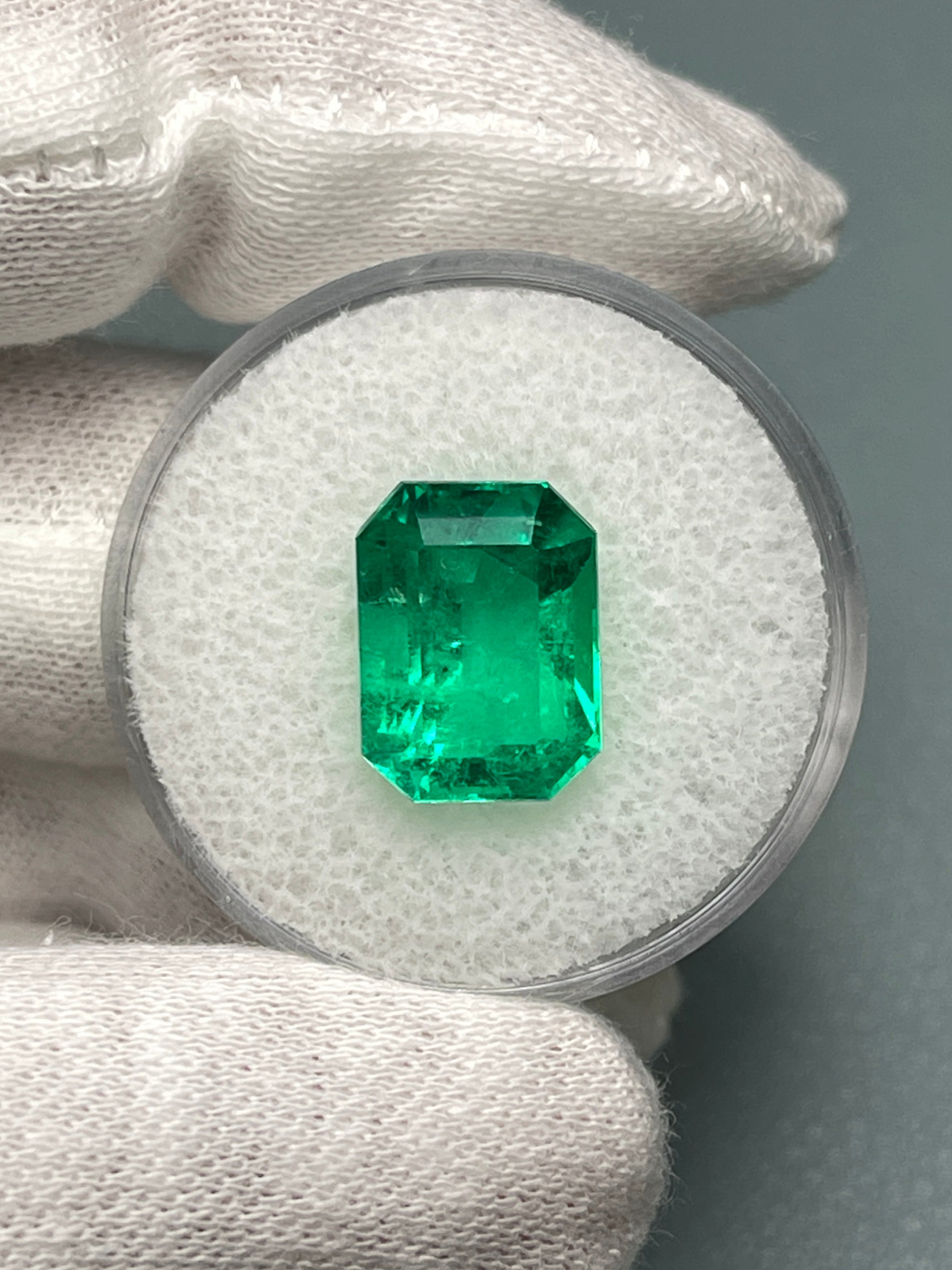 Vivid 5.71 carat Muzo green Colombian emerald loose gemstone in classic emerald cut, natural and vibrant.