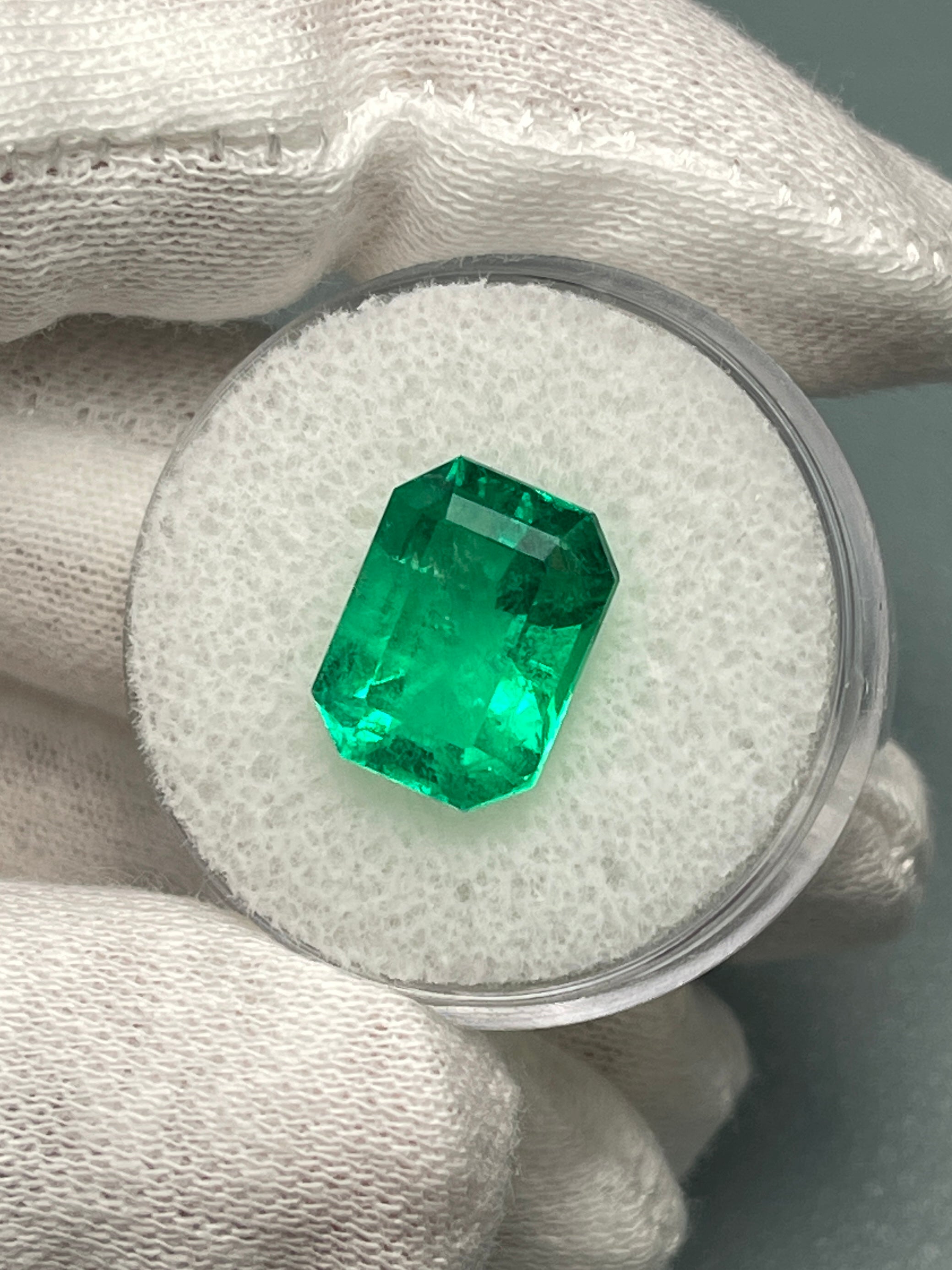 Vivid 5.71 carat Muzo green Colombian emerald loose gemstone in classic emerald cut, natural and vibrant.