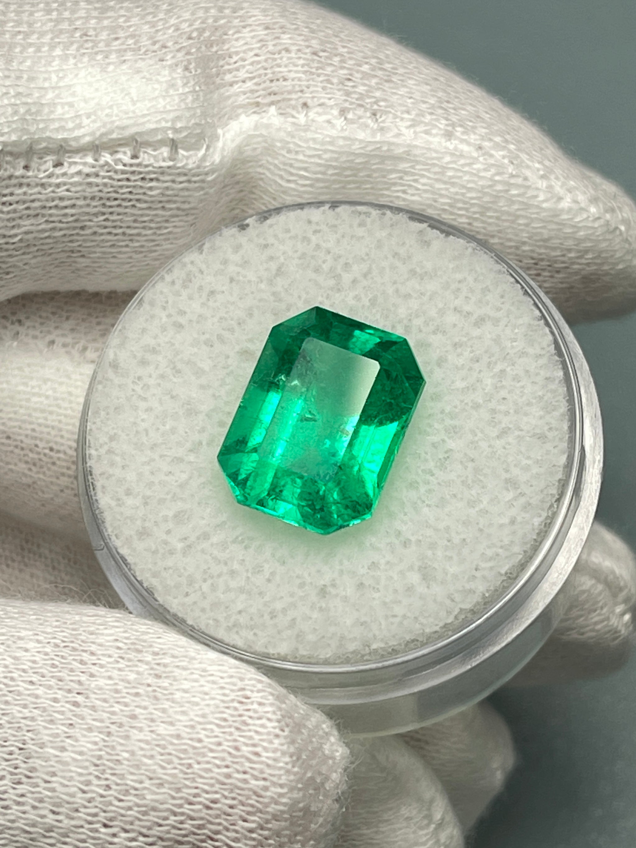 Vivid 5.71 carat Muzo green Colombian emerald in classic emerald cut, natural loose gemstone from JR Colombian Emeralds.
