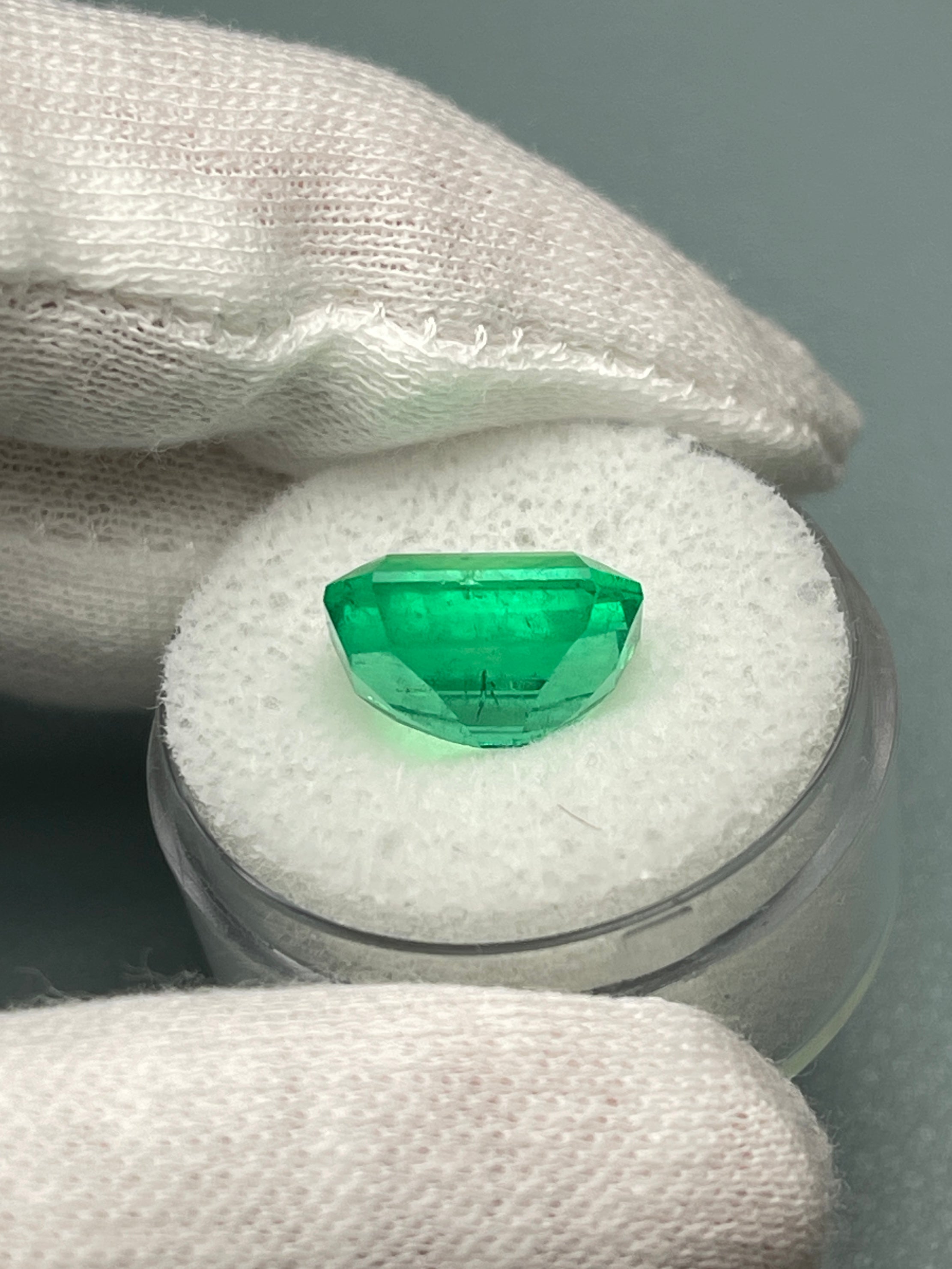 Vivid 5.71 carat Muzo green Colombian emerald loose gemstone in classic emerald cut, showcasing natural clarity and vibrant color.