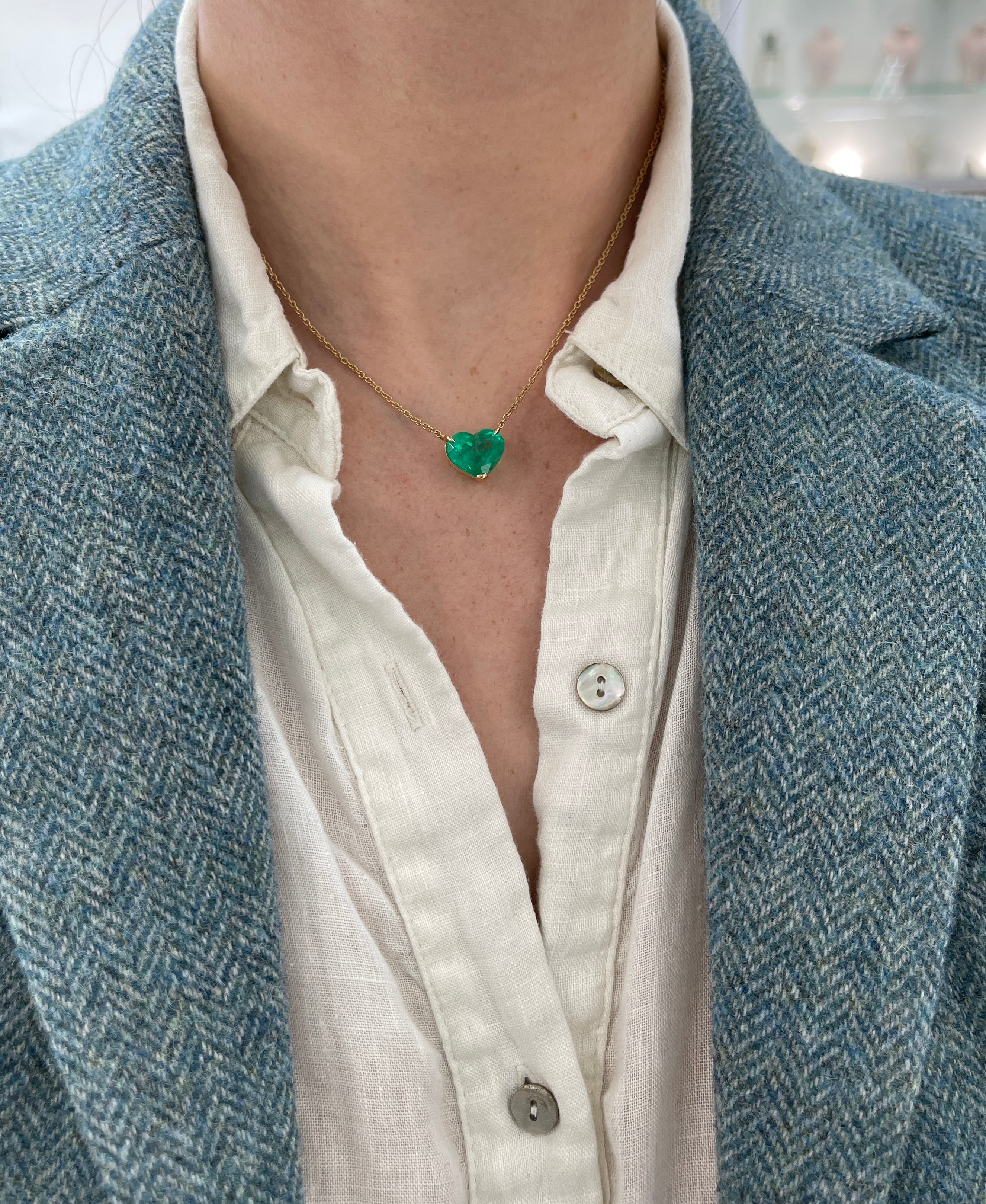 Colombian emerald heart-cut solitaire necklace by JR Colombian Emeralds featuring a 5.77-carat green gemstone on a gold chain.