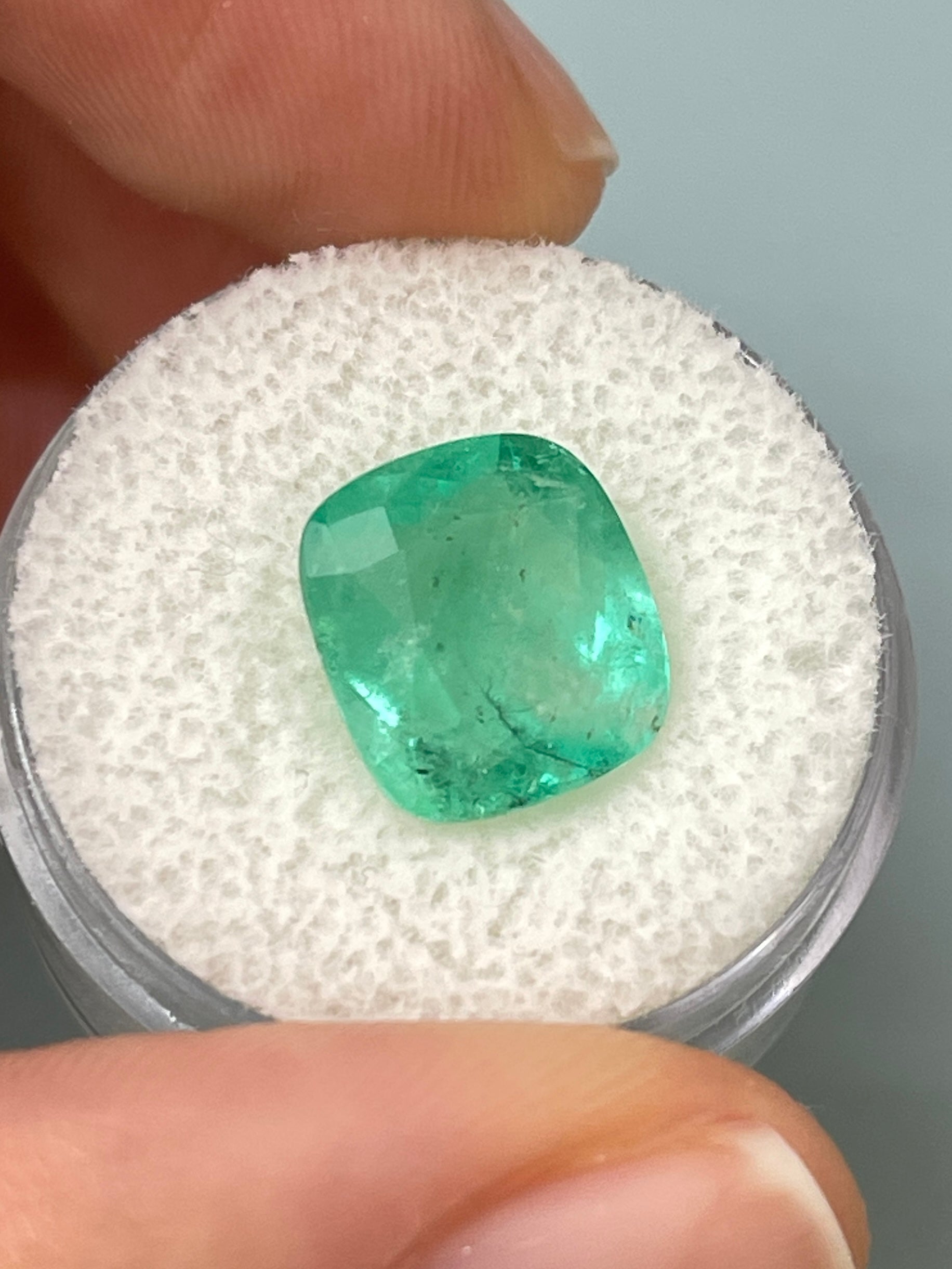 5.86 carat natural Colombian emerald in cushion cut with earthy pastel green hues, loose gemstone from JR Colombian Emeralds.
