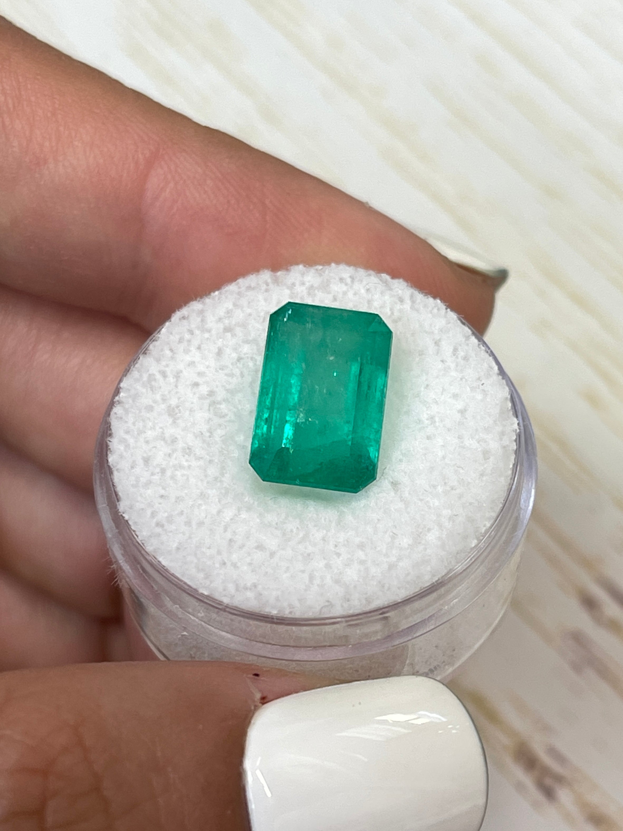 Bluish green 5.94 carat Colombian emerald loose gemstone in an emerald cut, showcasing natural color and clarity.