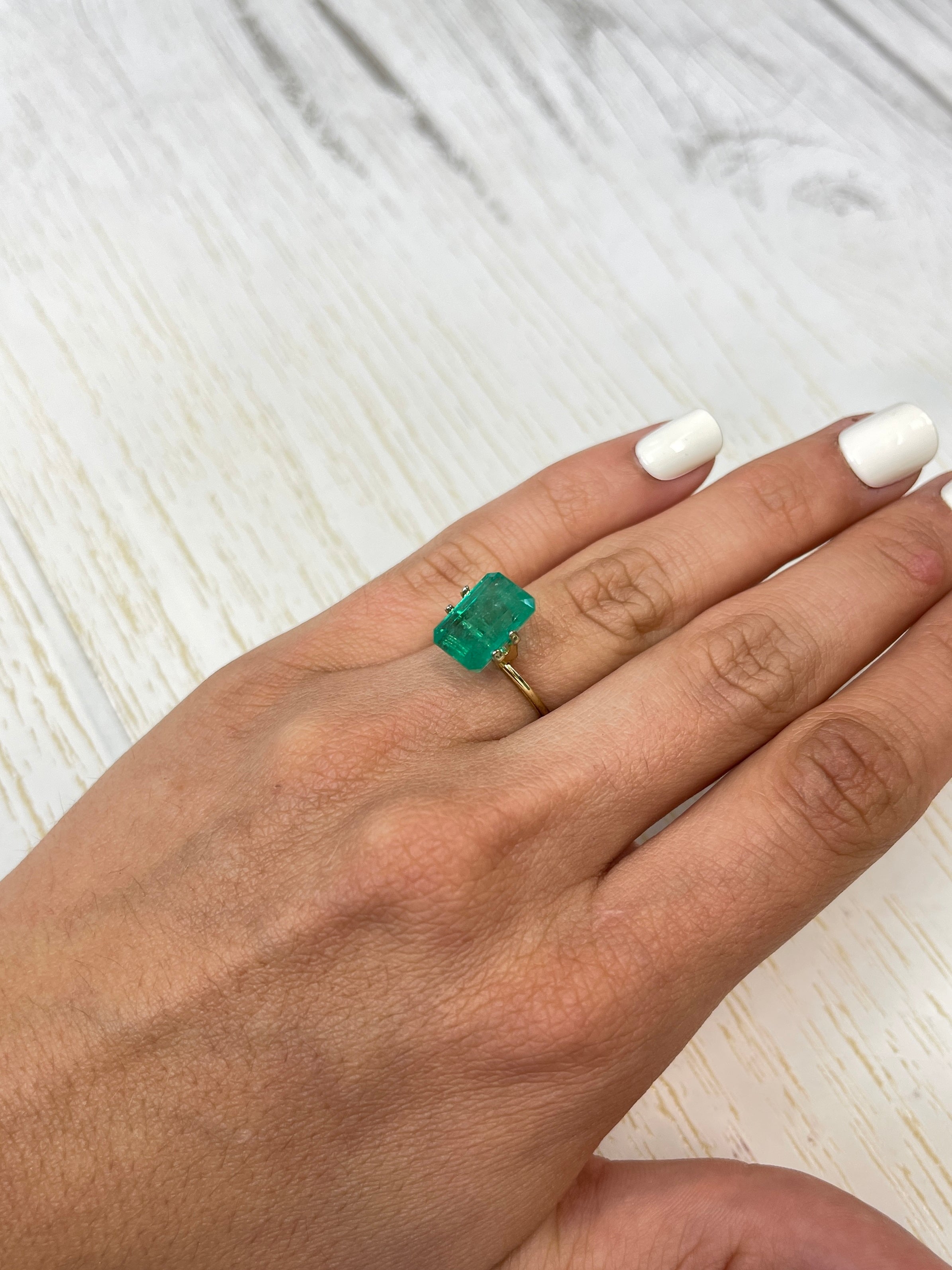 Bluish green 5.94 carat natural Colombian emerald loose gemstone in emerald cut, showcasing vibrant color and clarity.