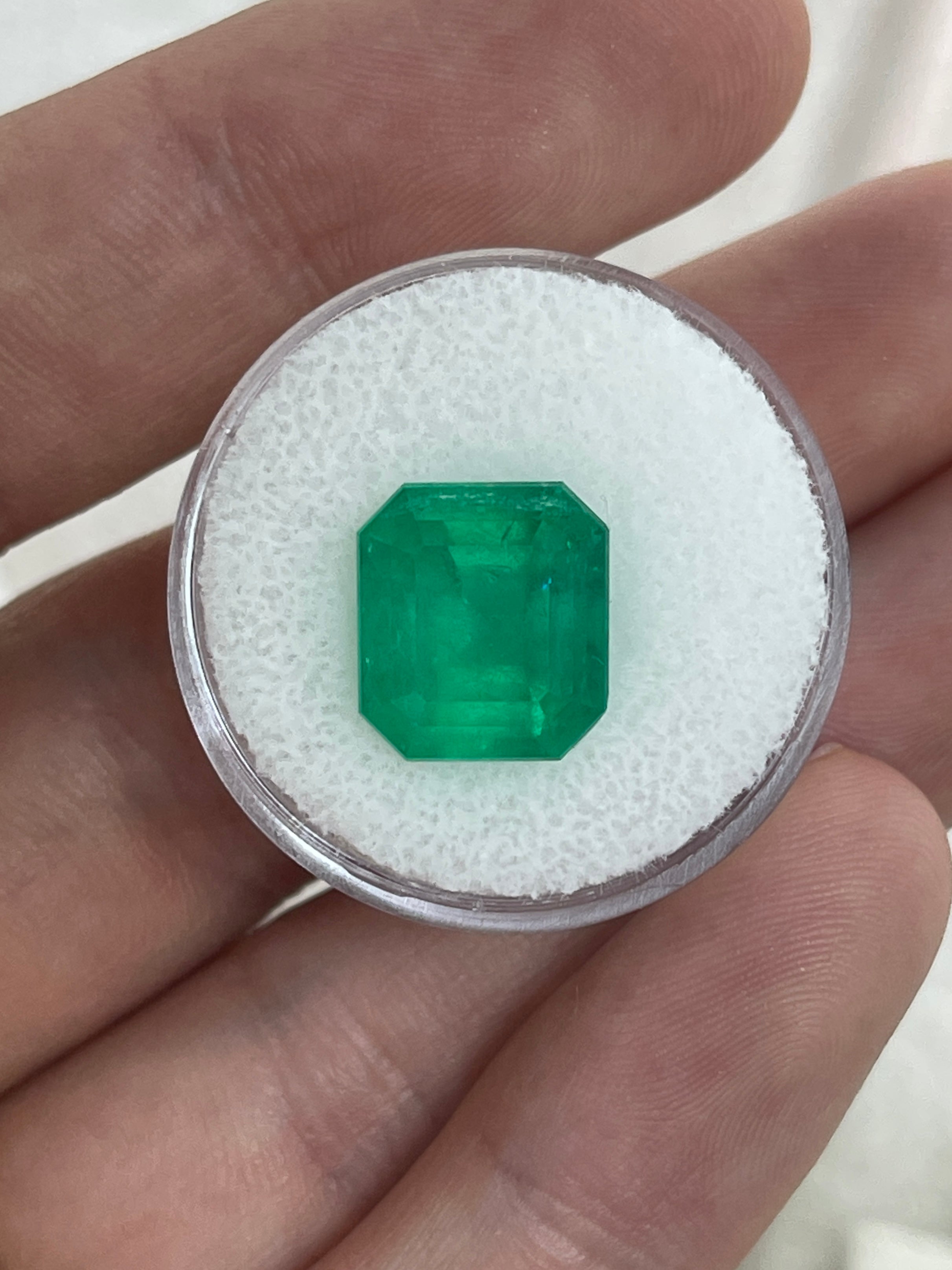 Deep green 5.94 carat natural Colombian emerald in an emerald cut, displayed as a loose gemstone, from JR Colombian Emeralds.
