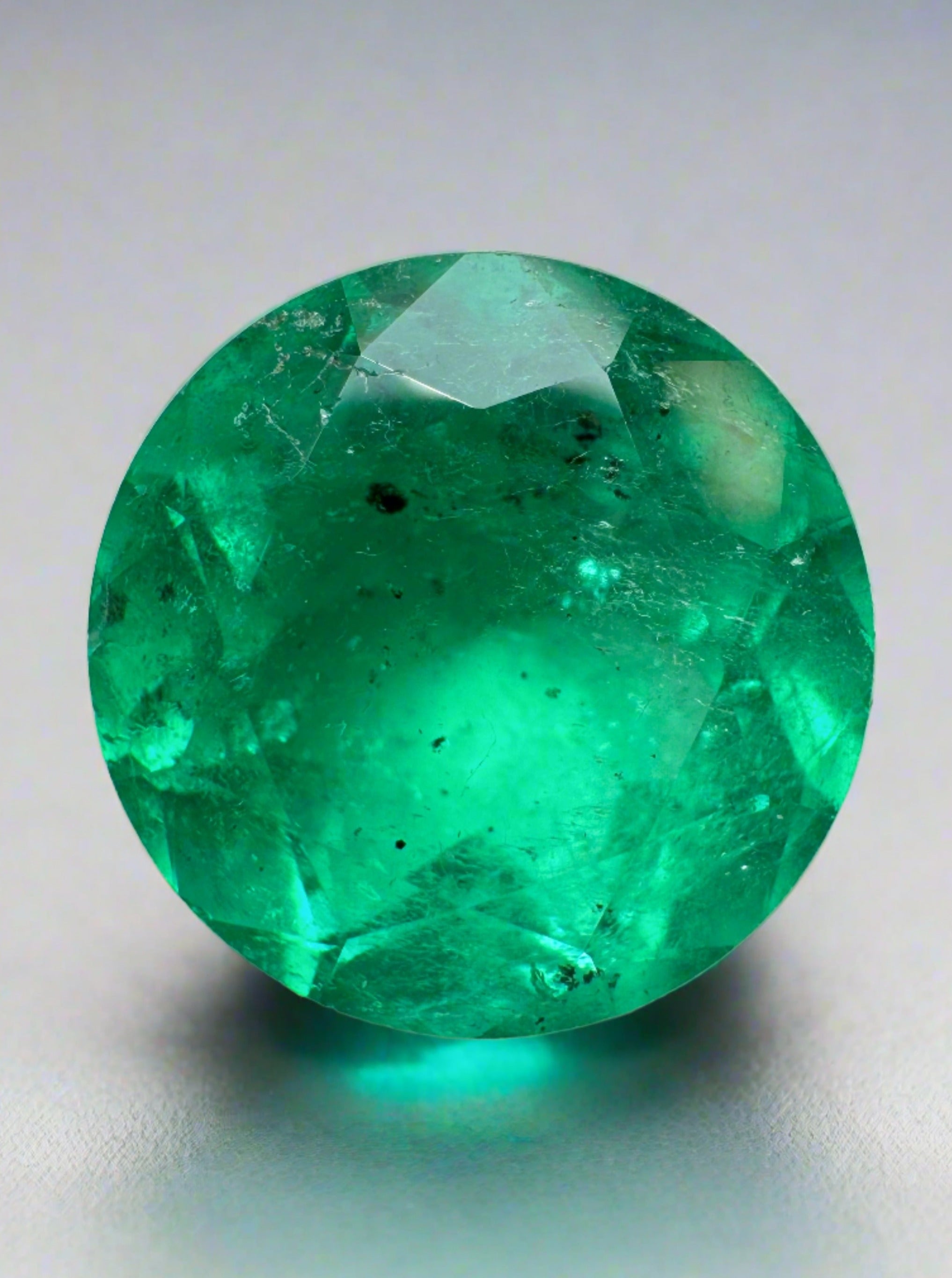 6.16 carat natural round Colombian emerald with freckles, vivid green color, loose gemstone from JR Colombian Emeralds.