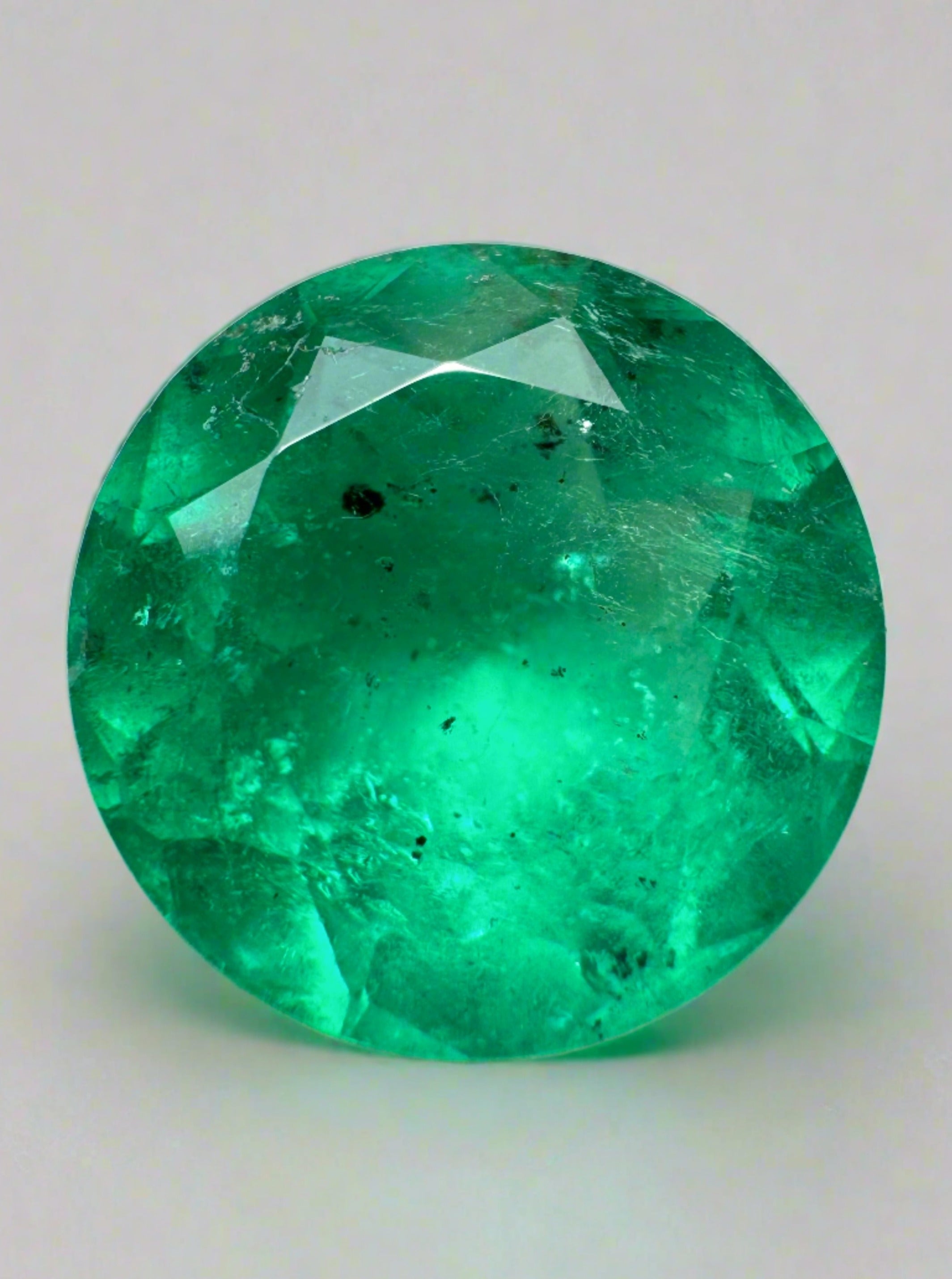6.16 carat natural round Colombian emerald with freckled green color, loose gemstone from JR Colombian Emeralds.