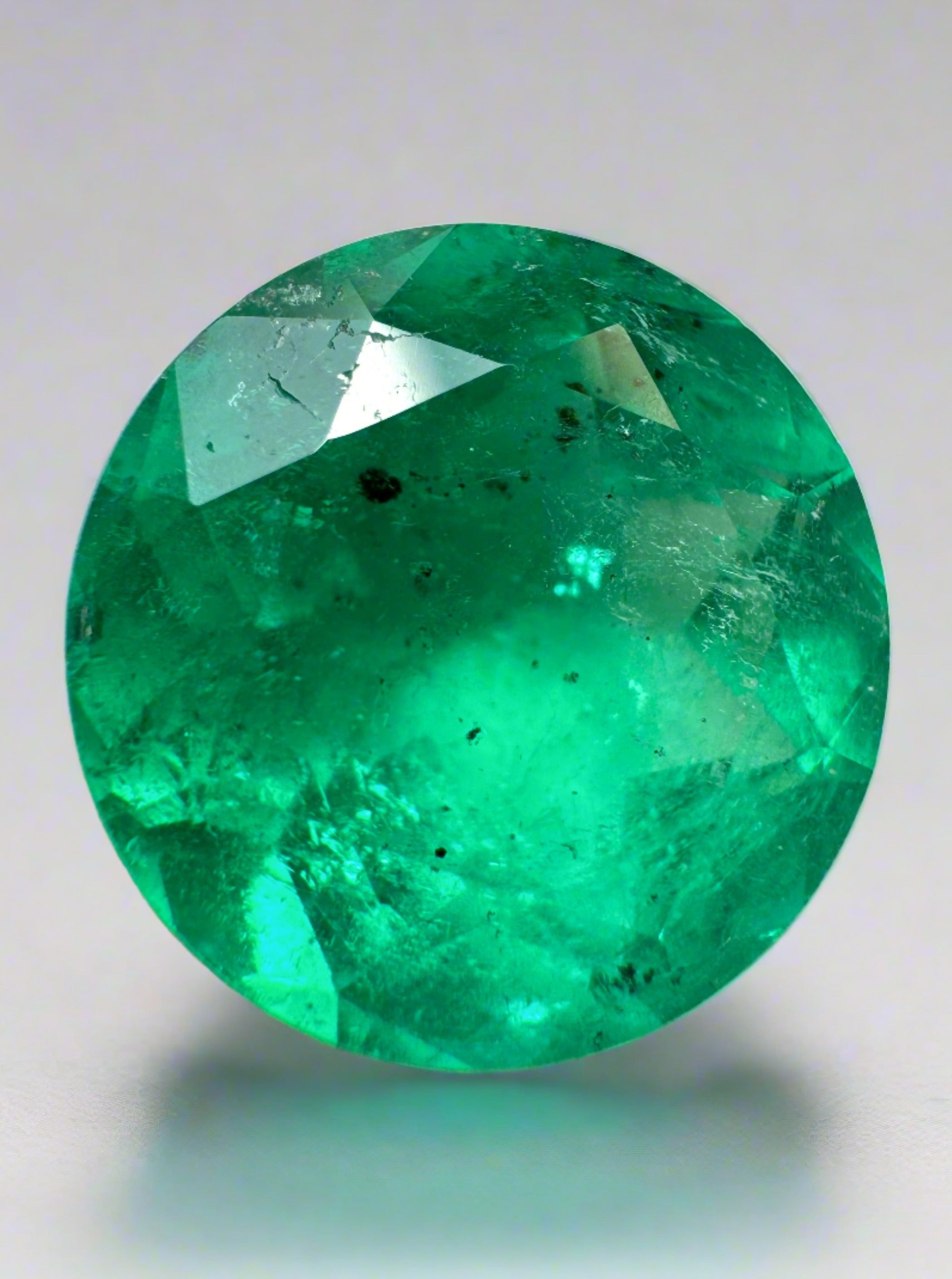 6.16 carat natural round Colombian emerald with freckled green color, loose gemstone from JR Colombian Emeralds.