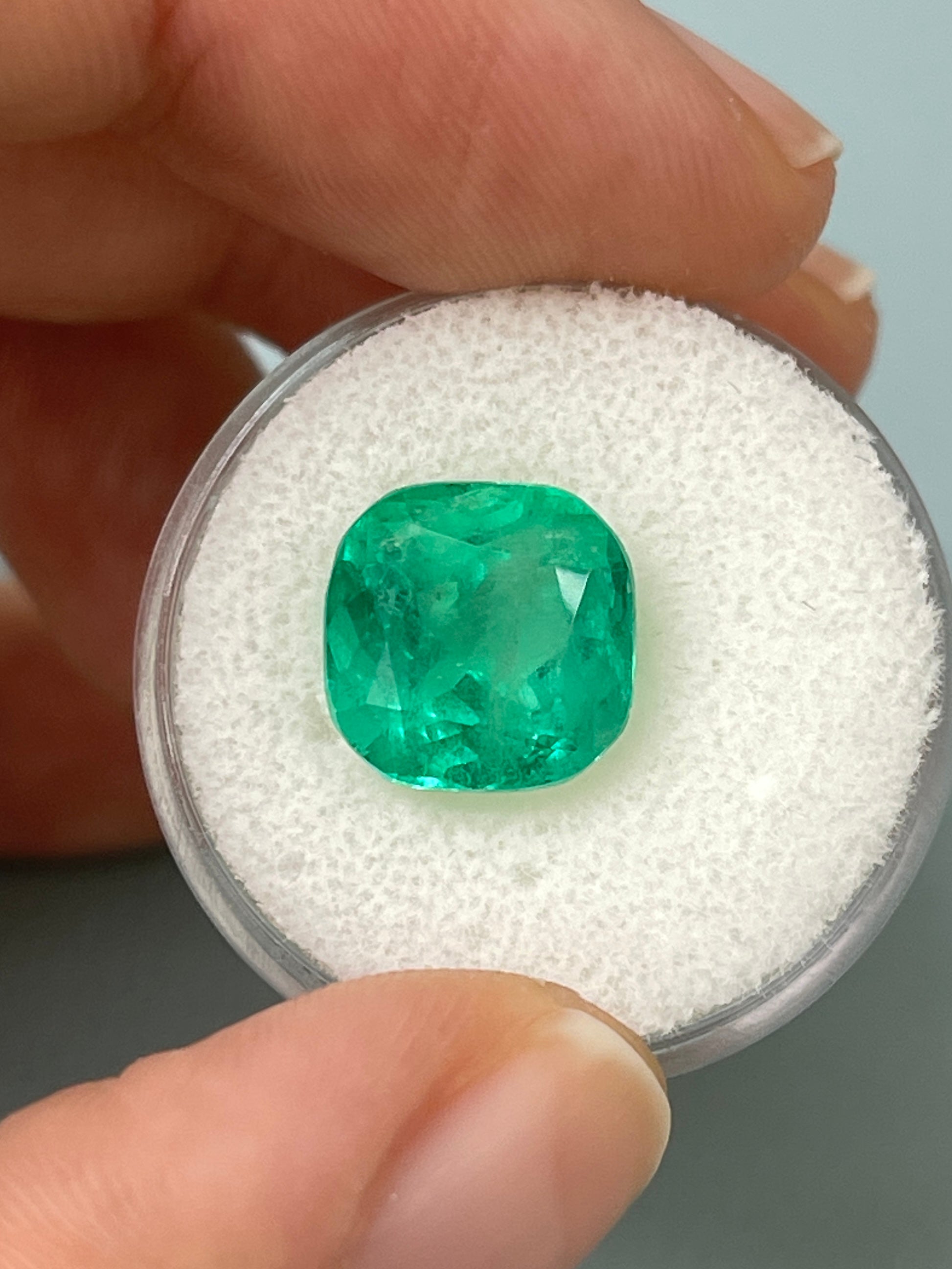 6.25 carat bluish green natural Colombian emerald loose cushion cut gemstone with vibrant color and clarity.