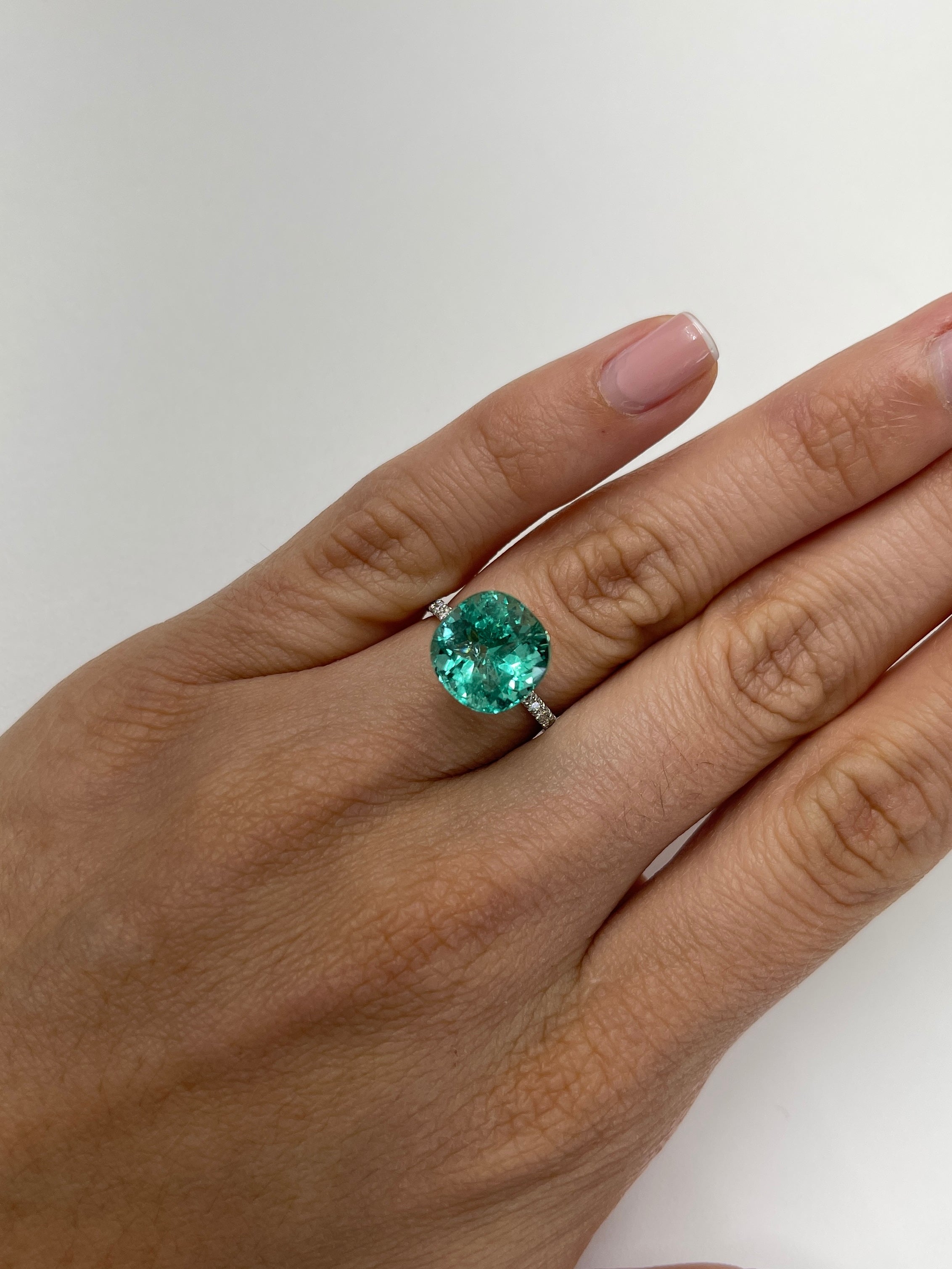 Luminous bluish-green 6.38 carat natural Colombian emerald in a cushion cut, loose gemstone showcasing vibrant color and clarity.