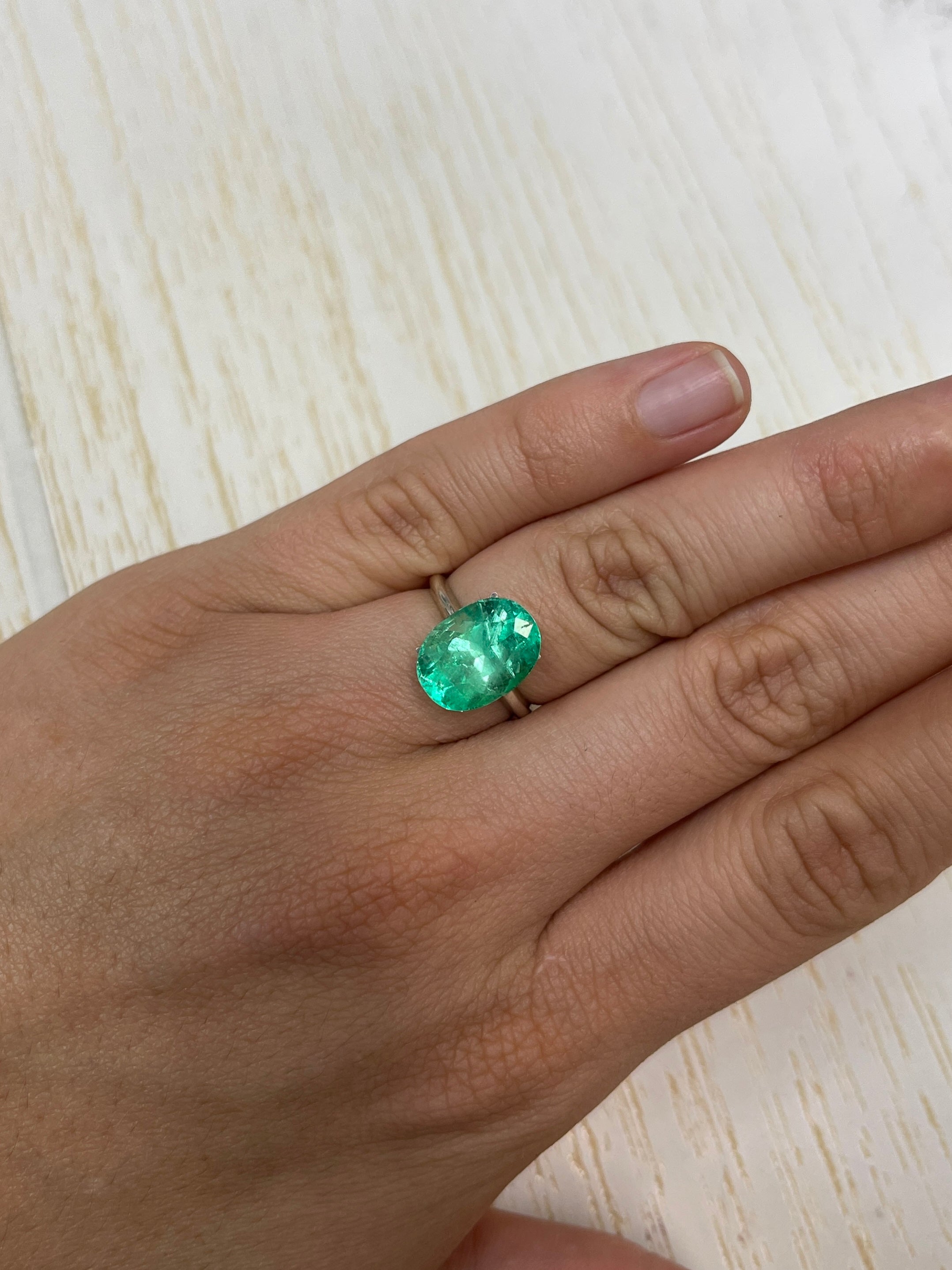 Medium green 6.40-carat natural Colombian emerald loose oval-cut gemstone, showcasing vibrant color and clarity.