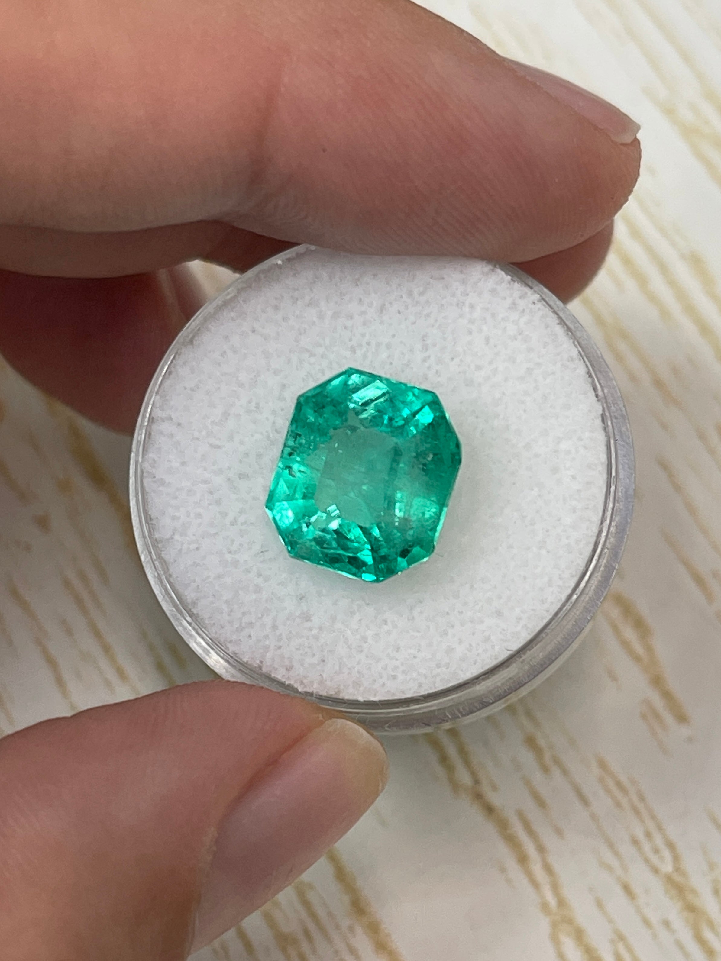 6.63 carat natural Colombian emerald loose gemstone with chunky 11x10 emerald cut, showcasing vibrant green color and clarity.
