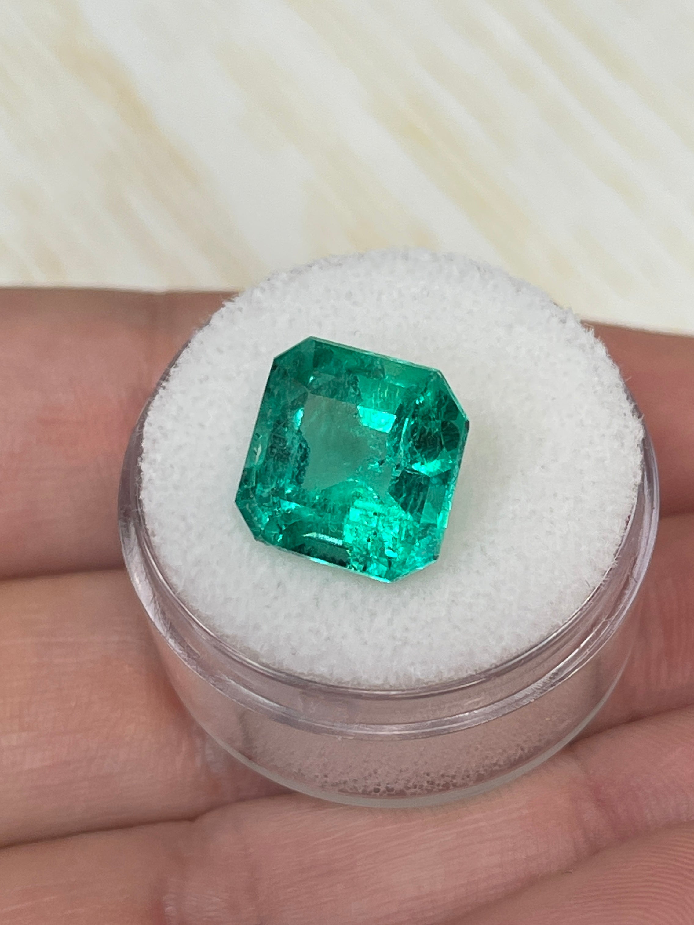 Vivid Muzo green 6.69 carat Colombian emerald loose Asscher cut, natural gemstone with vibrant green color and precise faceting.
