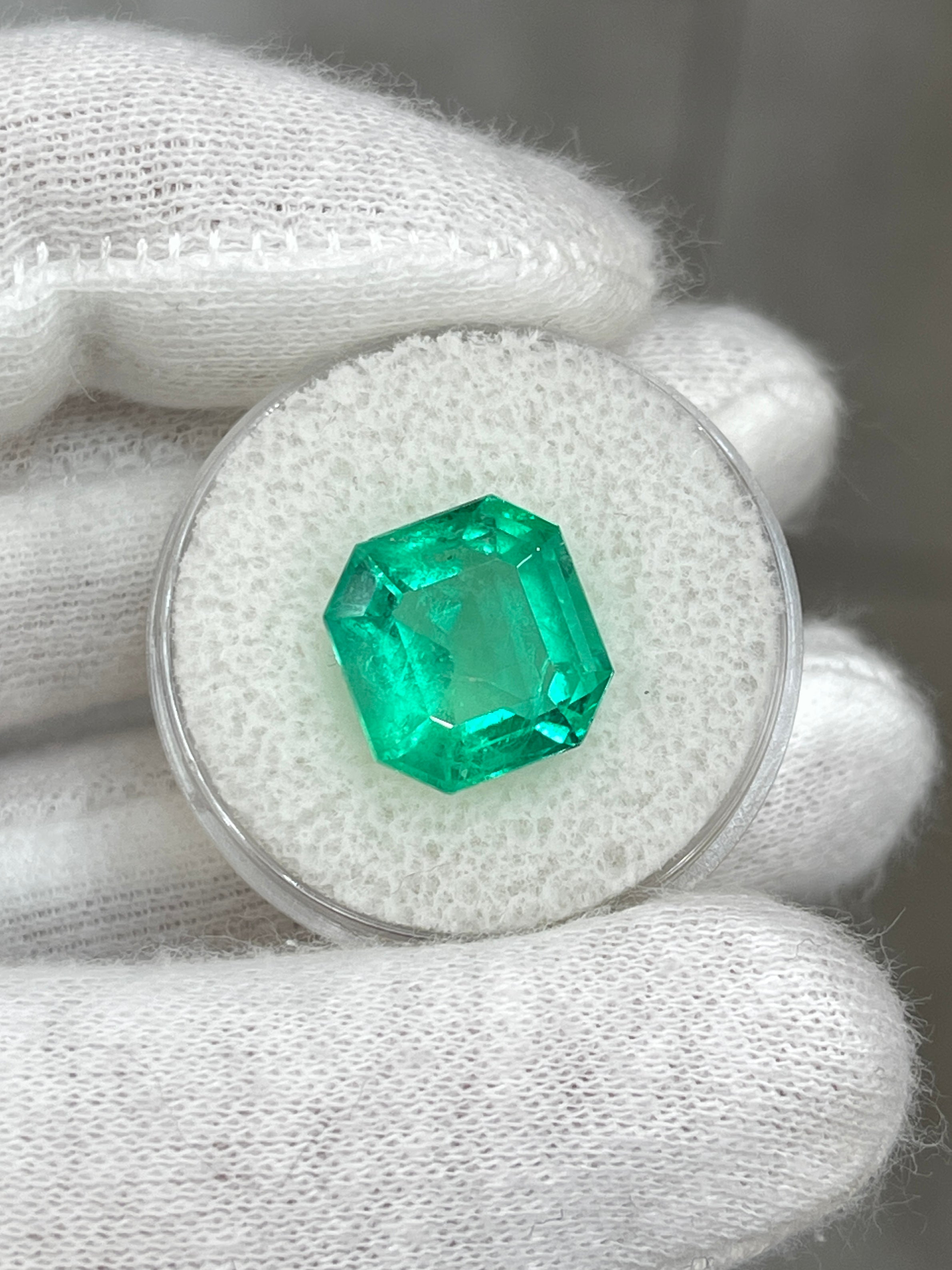 6.76 carat glowing green natural Colombian emerald loose Asscher cut gemstone, shown from above with detailed facets.