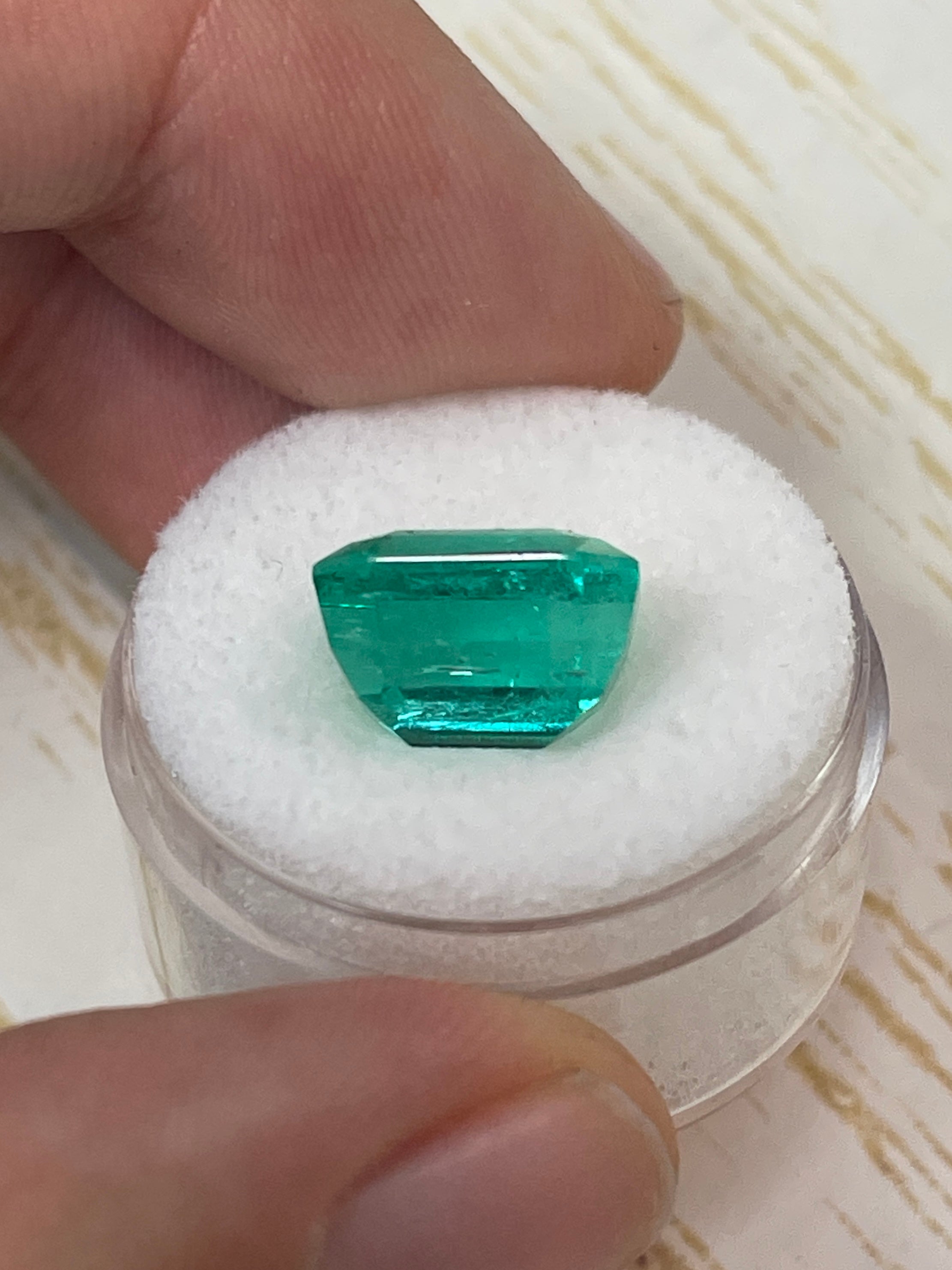 7.06 Carat bluish green Colombian emerald loose gemstone in emerald cut, showcasing vibrant color and clarity.