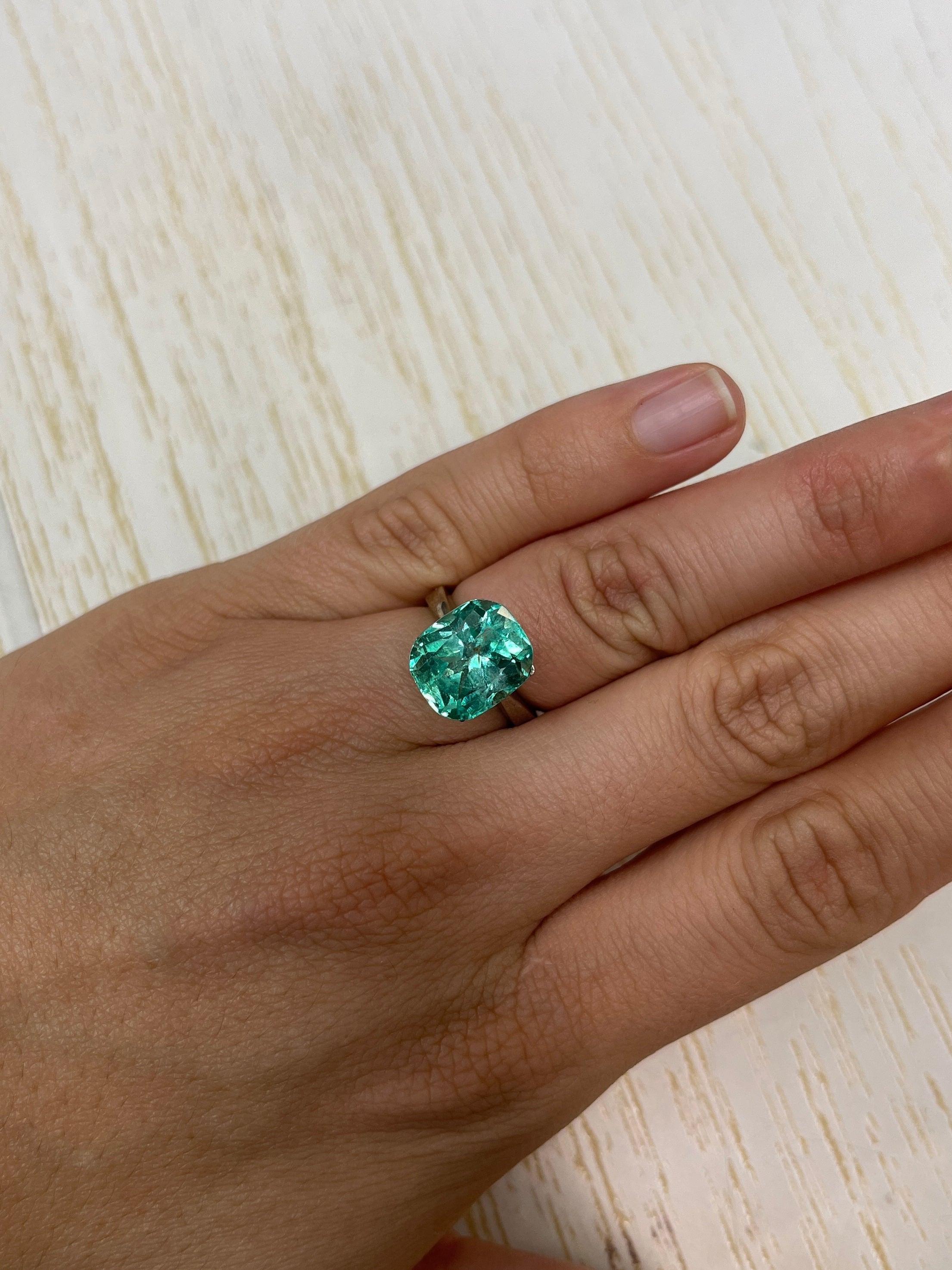 7.13 carat bluish green Colombian emerald loose cushion cut gemstone from JR Colombian Emeralds with vibrant natural color.