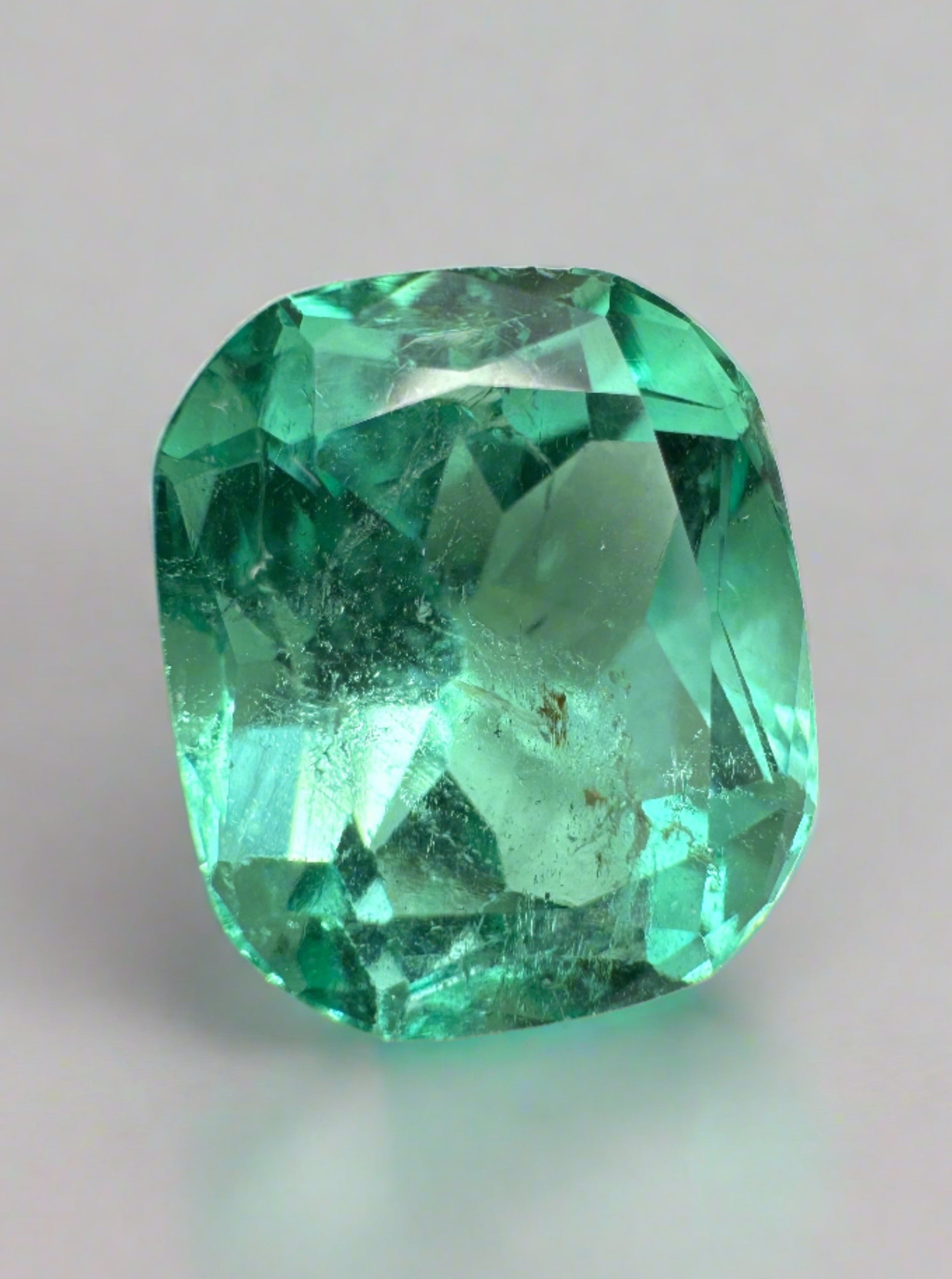 7.13 carat bluish green natural Colombian emerald loose cushion cut gemstone, vibrant and vivid in appearance.