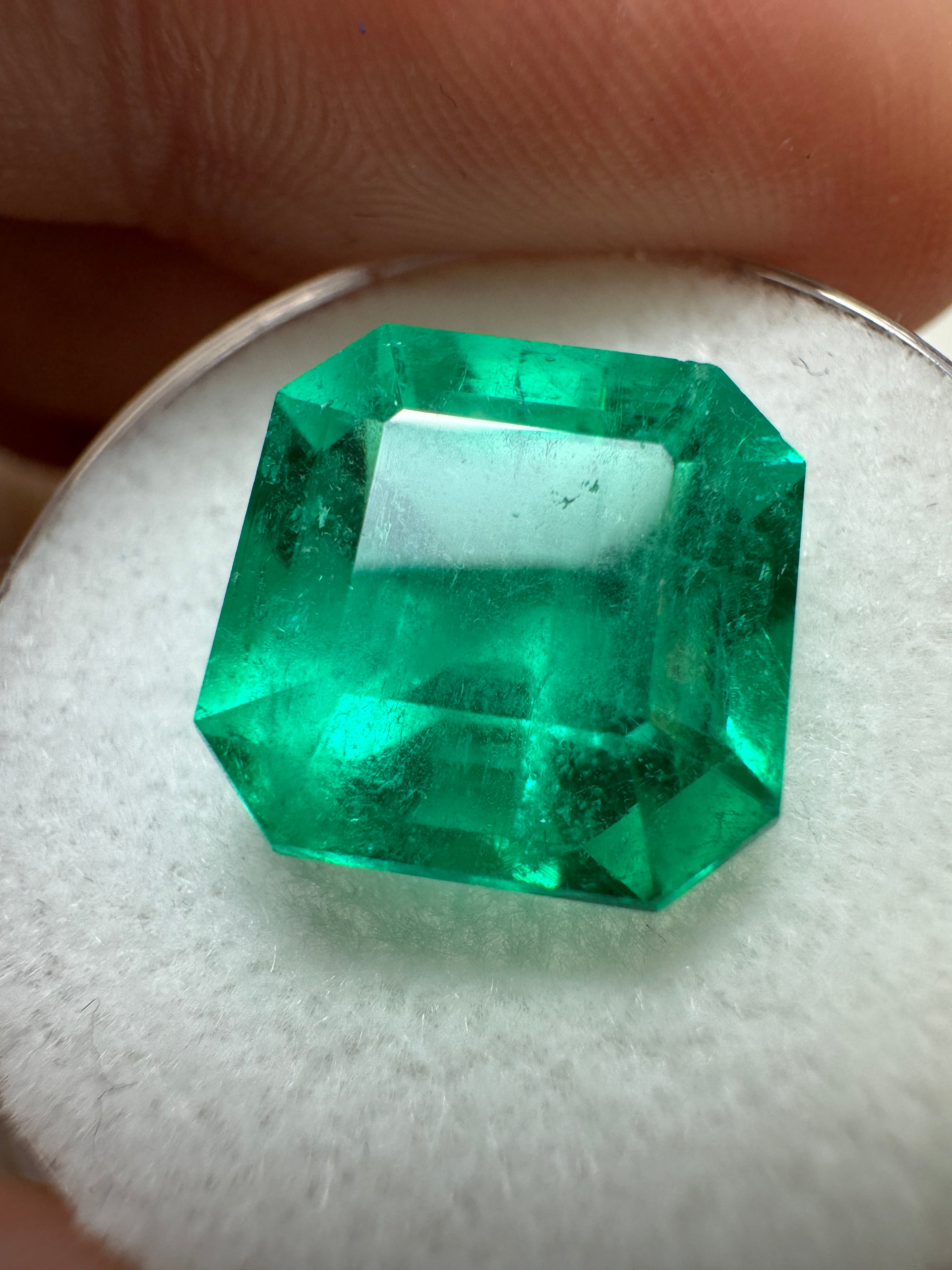 7.38 carat intense bluish green natural Colombian emerald loose gemstone in Asscher cut, showcasing vibrant color and clarity.