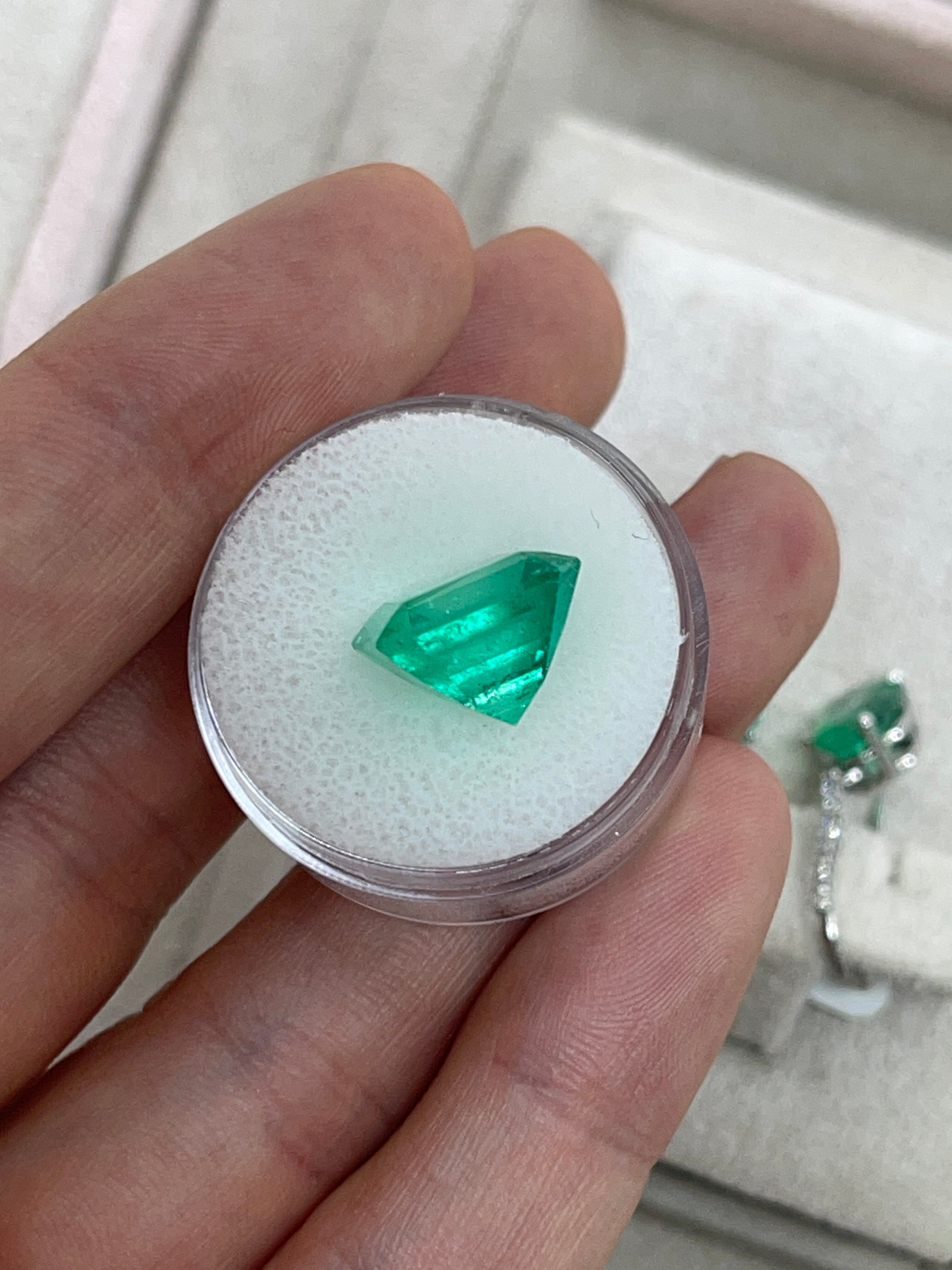 7.40 carat Muzo intense green natural Colombian emerald loose gemstone in Asscher cut, showcasing vivid color and clarity.