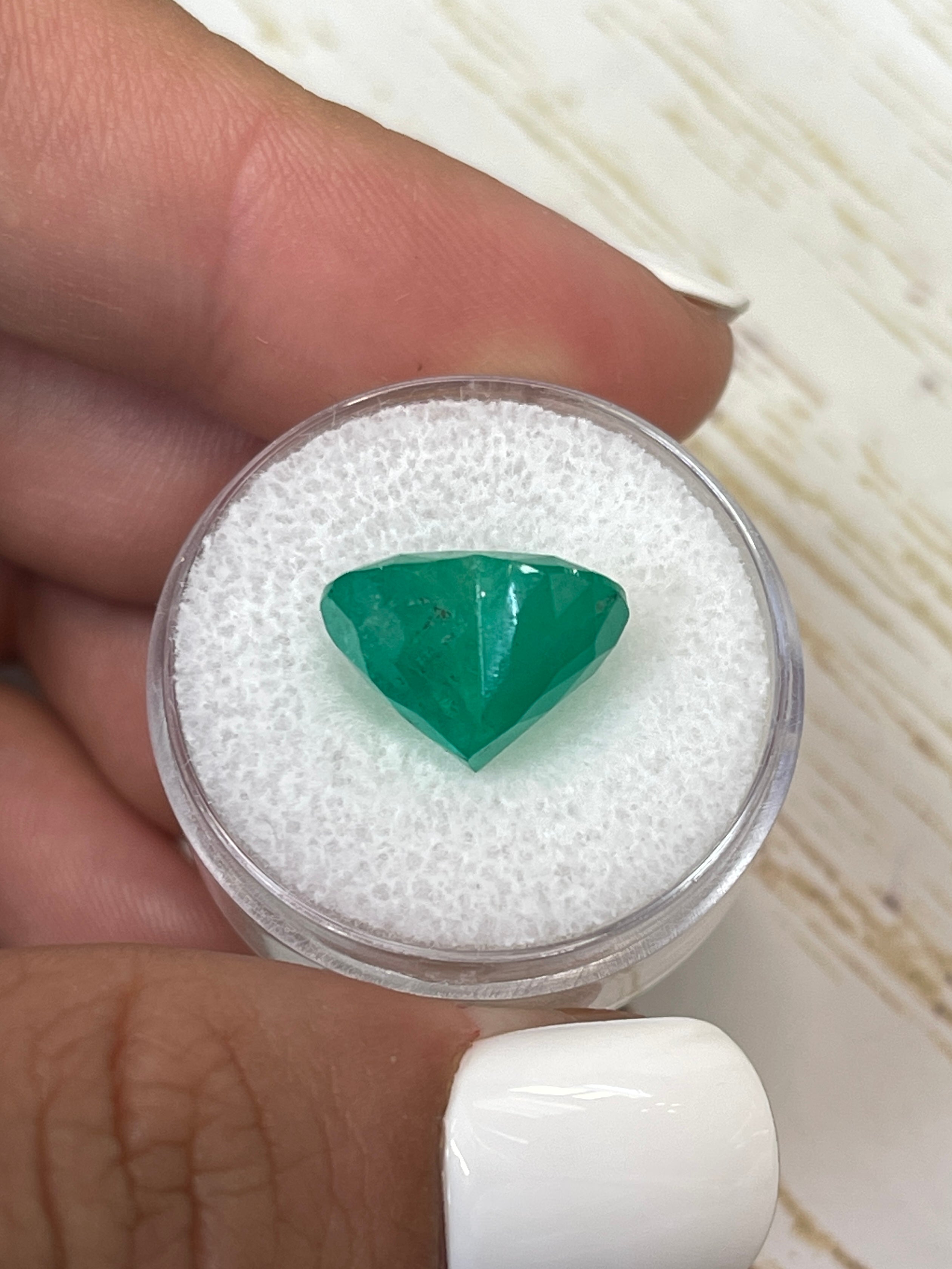 Natural 7.68 carat forest green Colombian emerald loose gemstone with heart cut, showcasing vibrant color and clarity.