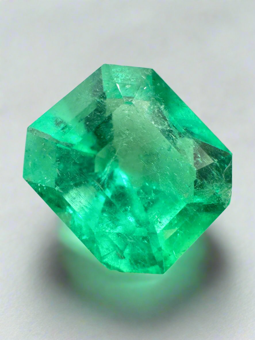 7.92 carat Colombian emerald cut loose emerald from JR Colombian Emeralds with a chunky 13x11.5 mm shape and vibrant green hue.
