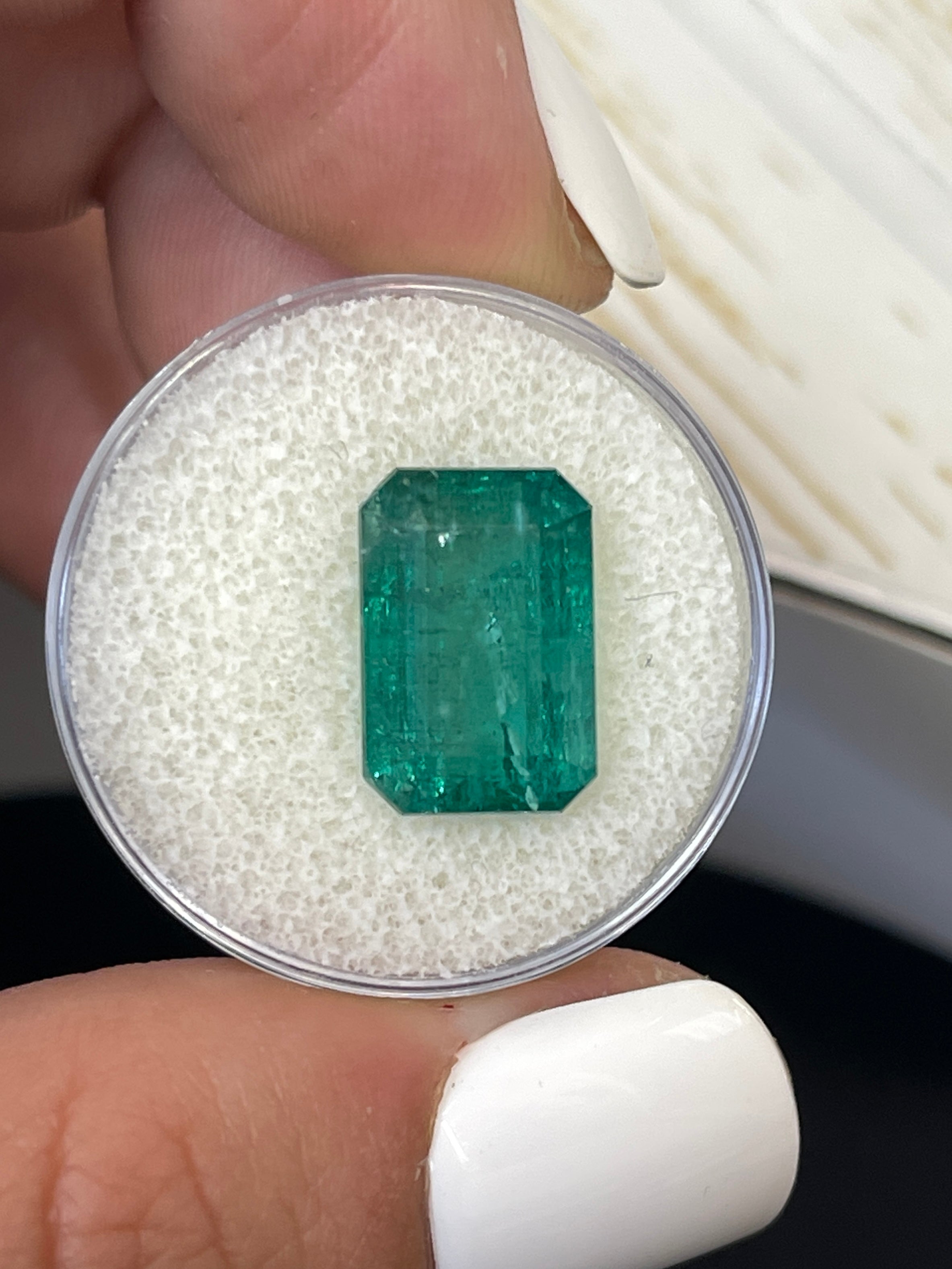 7.96 carat natural green Zambian emerald cut loose gemstone with 14x9mm elongated shape, displayed by JR Colombian Emeralds.