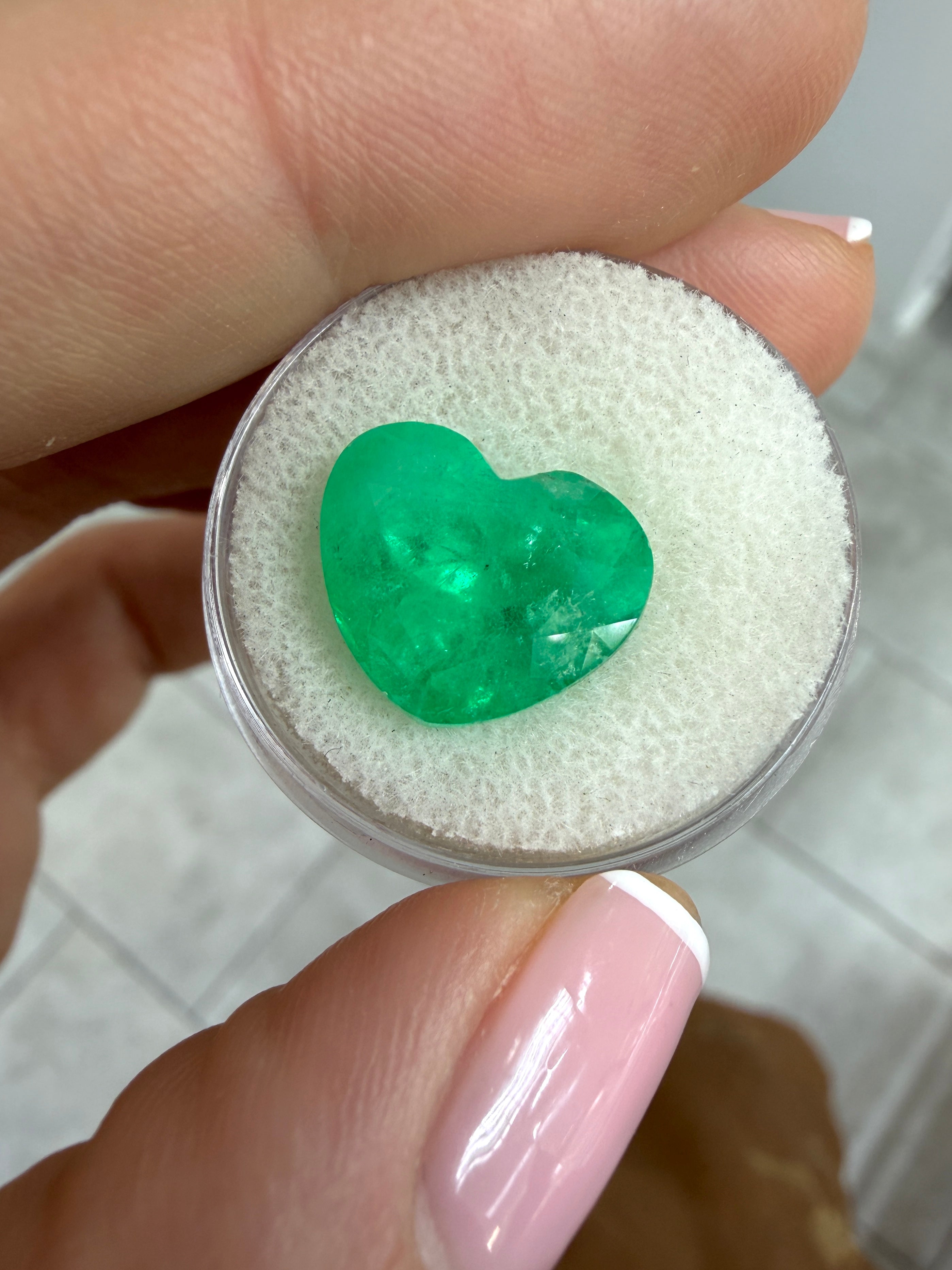 Large 8.47 carat medium green Colombian emerald loose gemstone with heart cut, showcasing natural color and clarity.