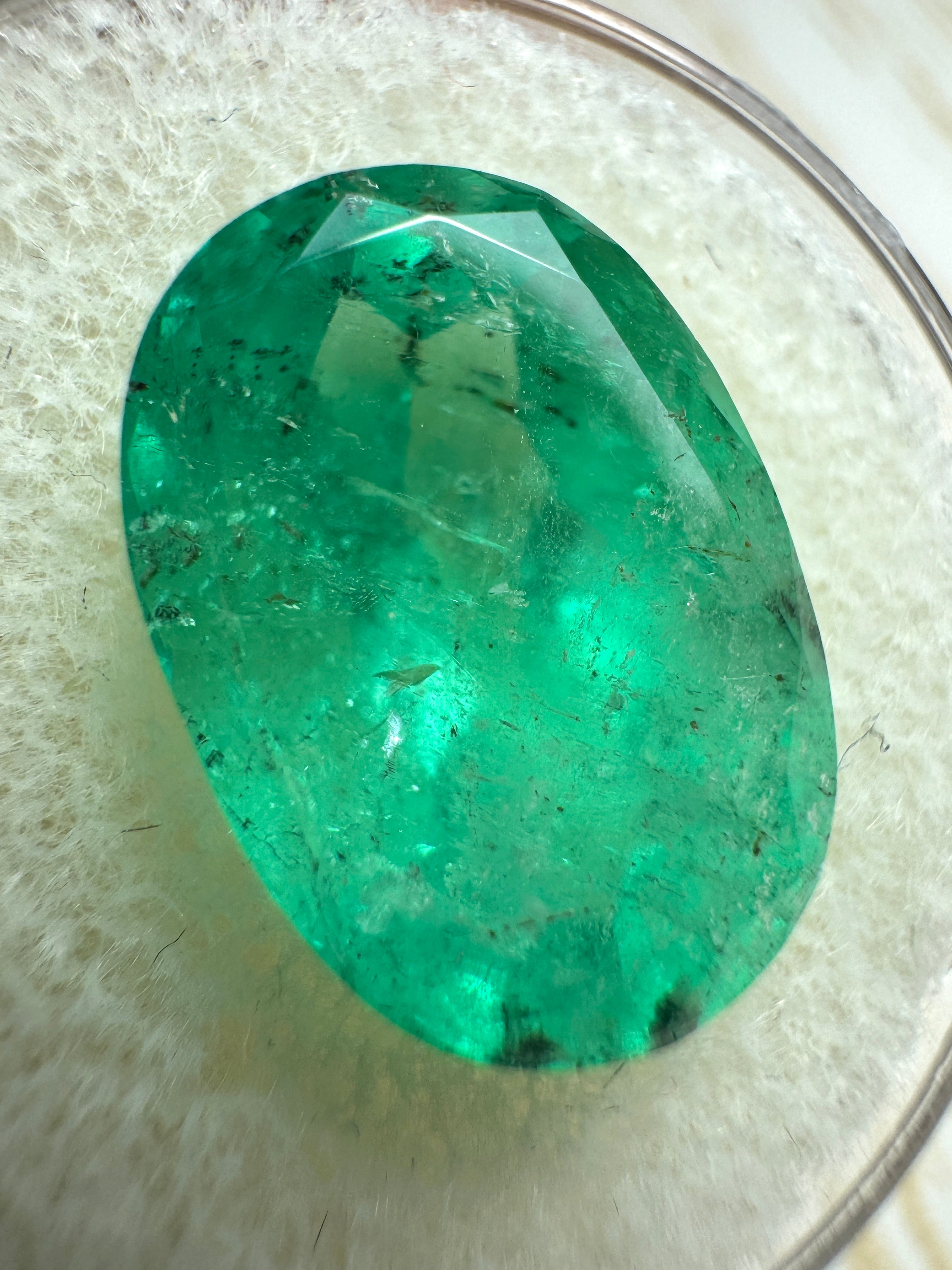 8.64-carat freckled medium green Colombian emerald in oval cut, natural loose gemstone from JR Colombian Emeralds.