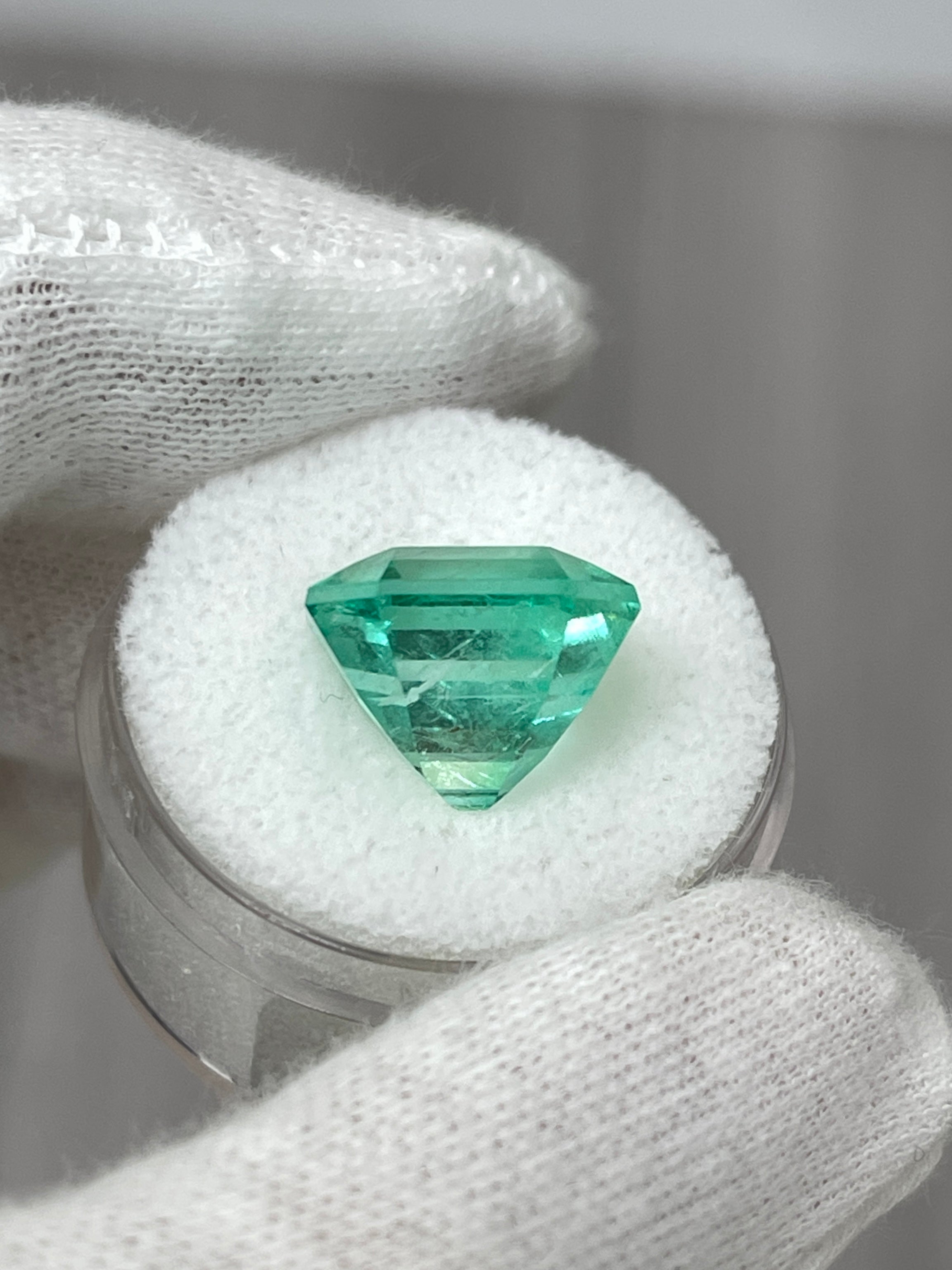 Large 10.49 carat Colombian emerald in classic 13x13 Asscher cut, featuring vibrant green color and natural clarity.