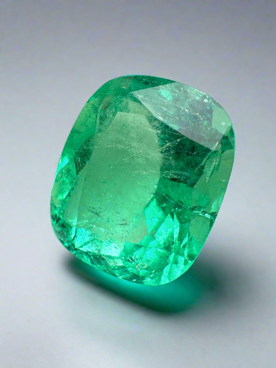 Large 11.50 carat natural Colombian emerald cushion cut with yellowish hue, from JR Colombian Emeralds.