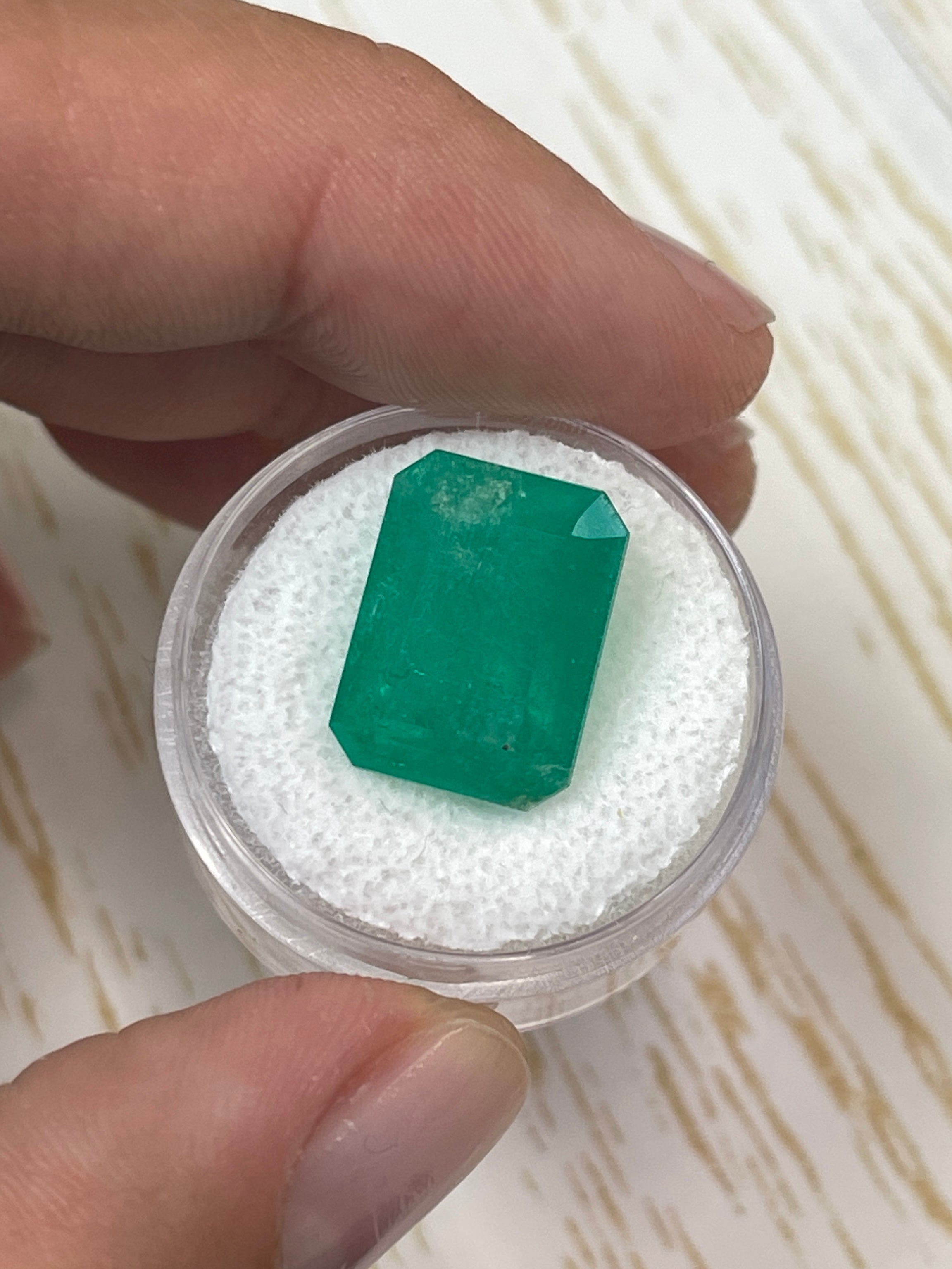 Large 12.13 carat natural Colombian emerald in an emerald cut, showcasing vibrant green color and clarity.