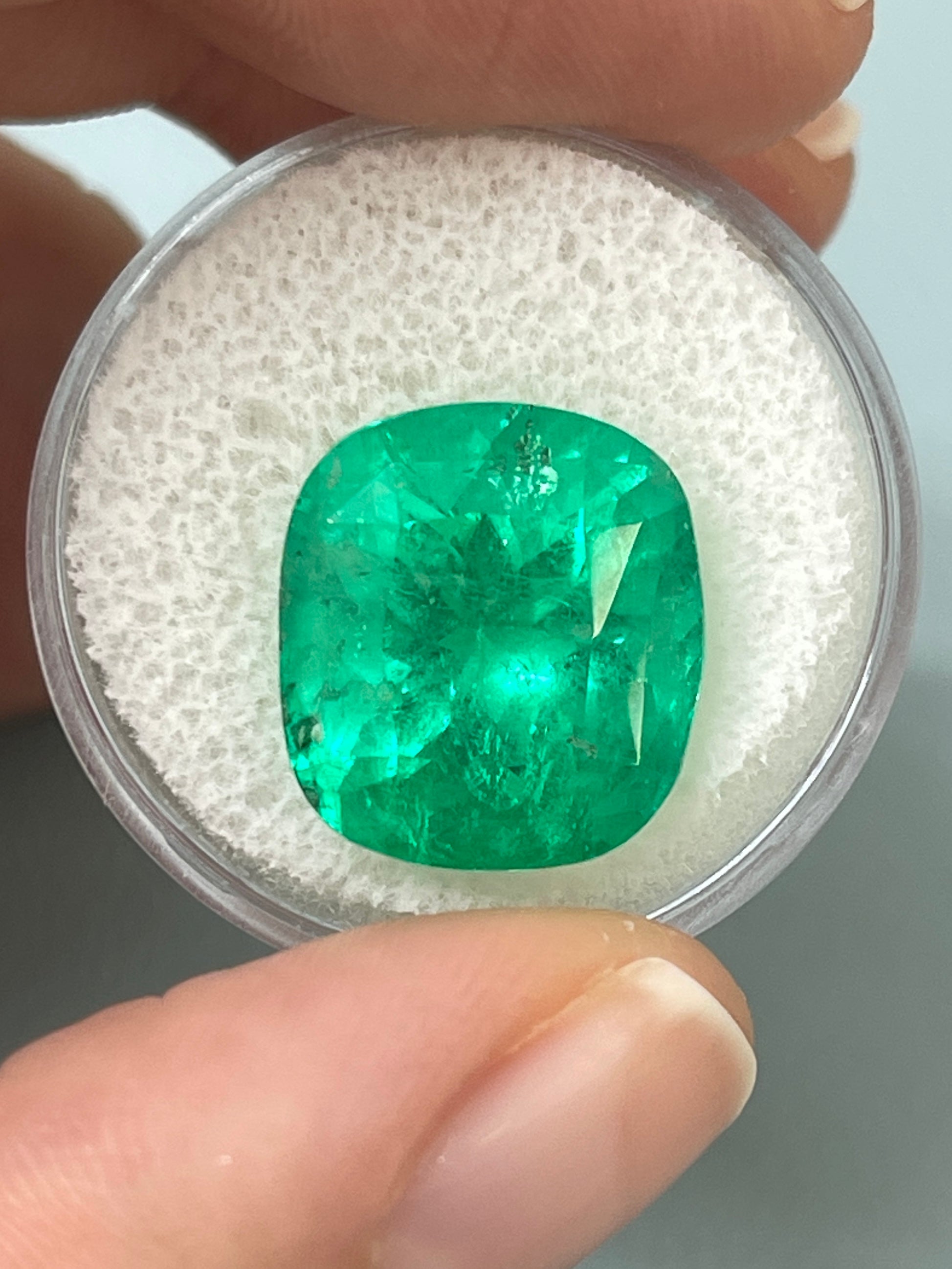 Large 12.27 carat Muzo yellowish green Colombian emerald in cushion cut, natural loose gemstone from JR Colombian Emeralds.
