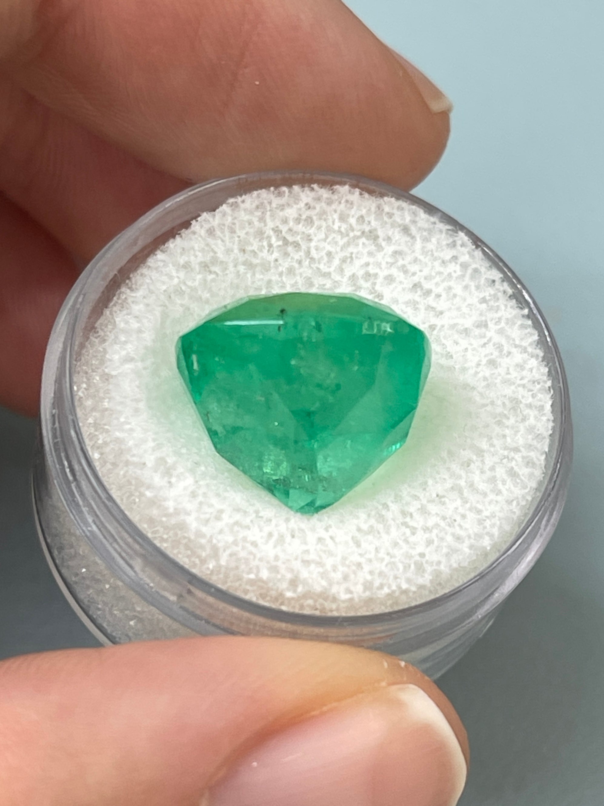 Large 12.66 carat natural Colombian emerald in 14x14 cushion cut, from JR Colombian Emeralds. Green gemstone with brilliant facets.