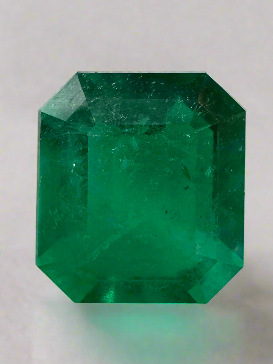 Large 13.04 carat AAA+ Colombian emerald loose gemstone in an emerald cut, showcasing vibrant green color and clarity.