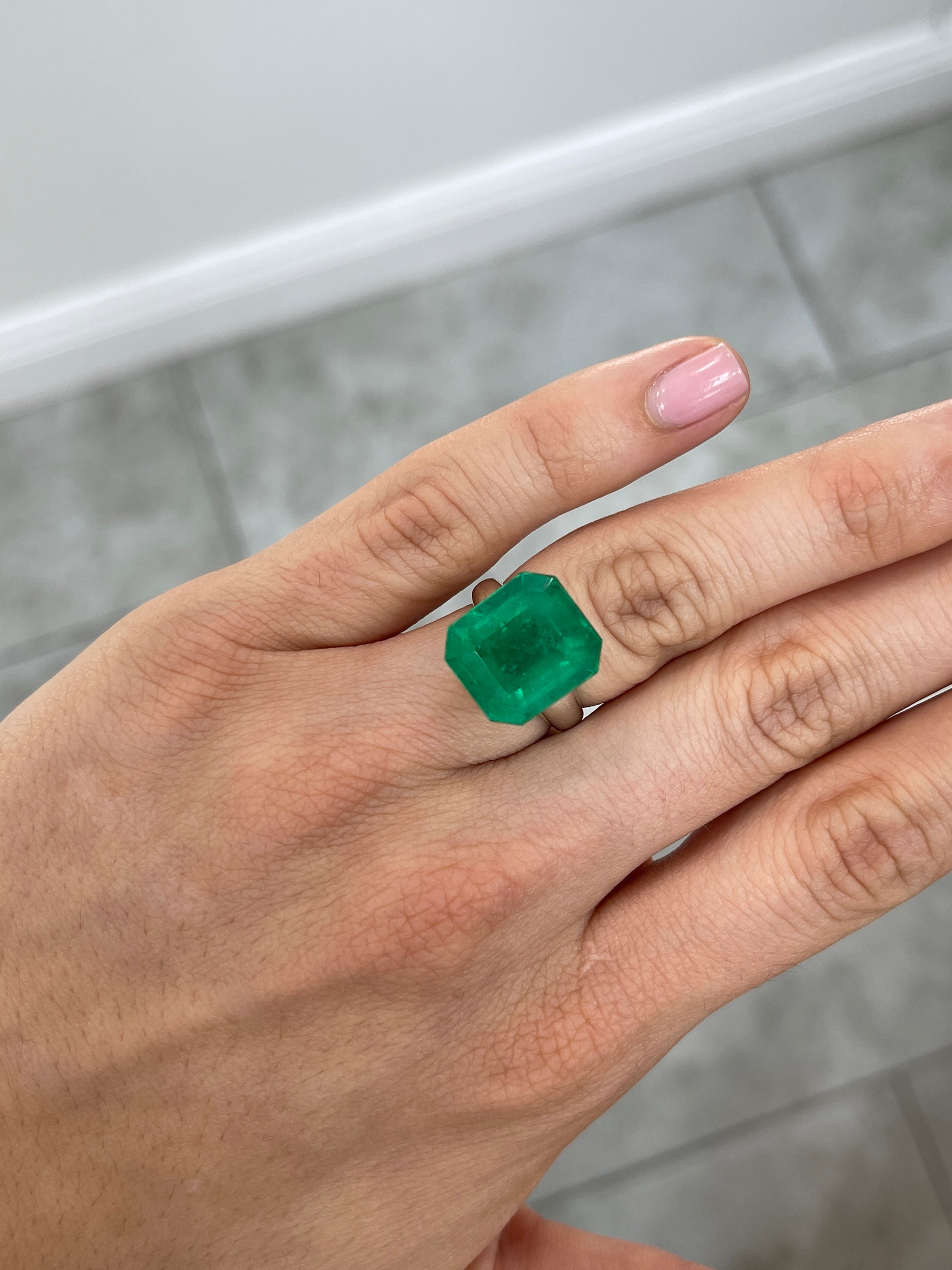Large 13.04 carat AAA+ Colombian emerald loose gemstone in emerald cut, measuring 15x14 mm, from JR Colombian Emeralds.