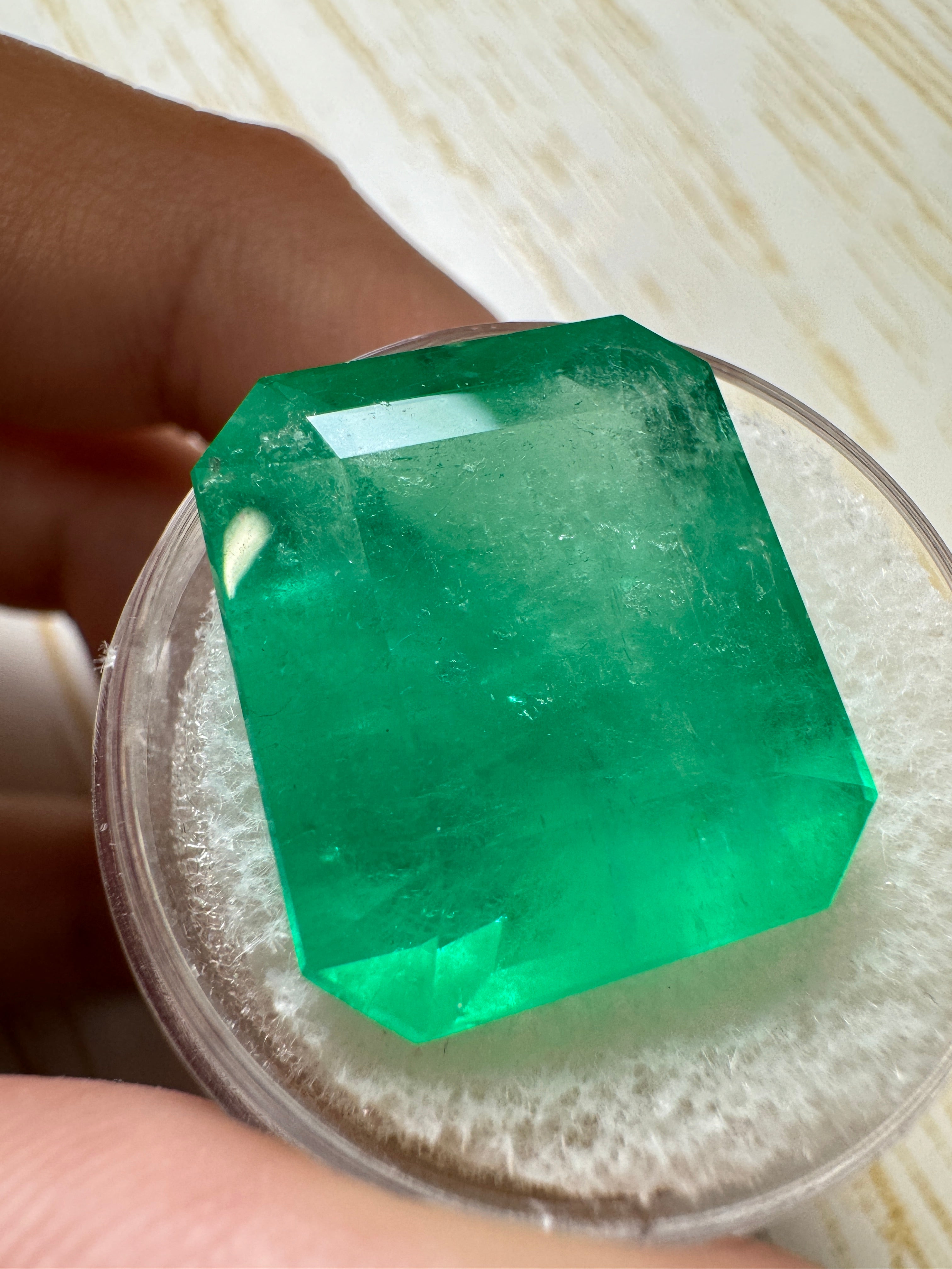 Large 22.54 carat natural Colombian emerald in an emerald cut, showcasing vibrant green color and clarity.