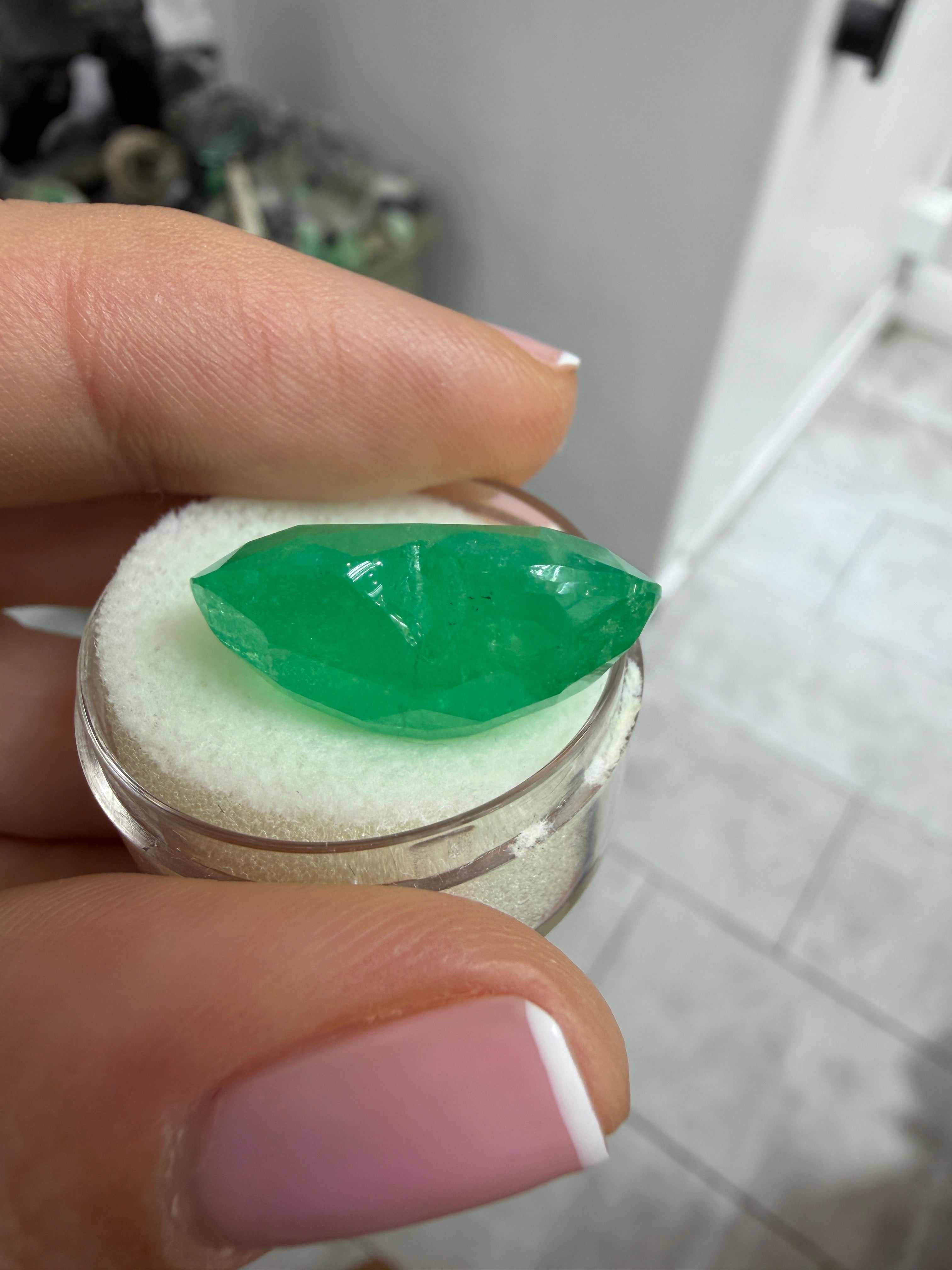 Large 23.97 carat bright green natural Colombian emerald in heart cut, showcasing its vibrant color and clarity.