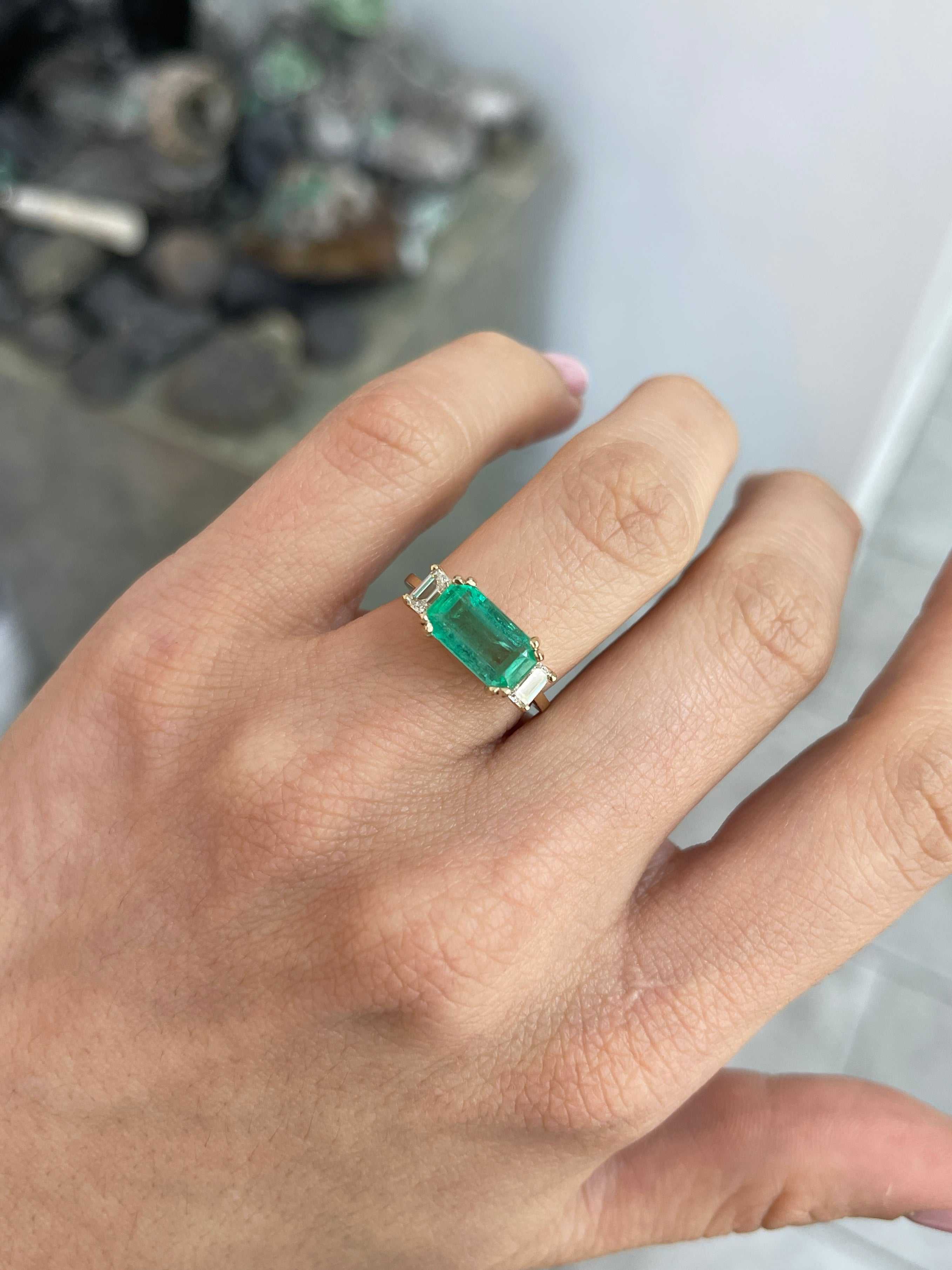 Three-stone engagement ring featuring emerald and diamond accents, set in 14K gold by JR Colombian Emeralds.