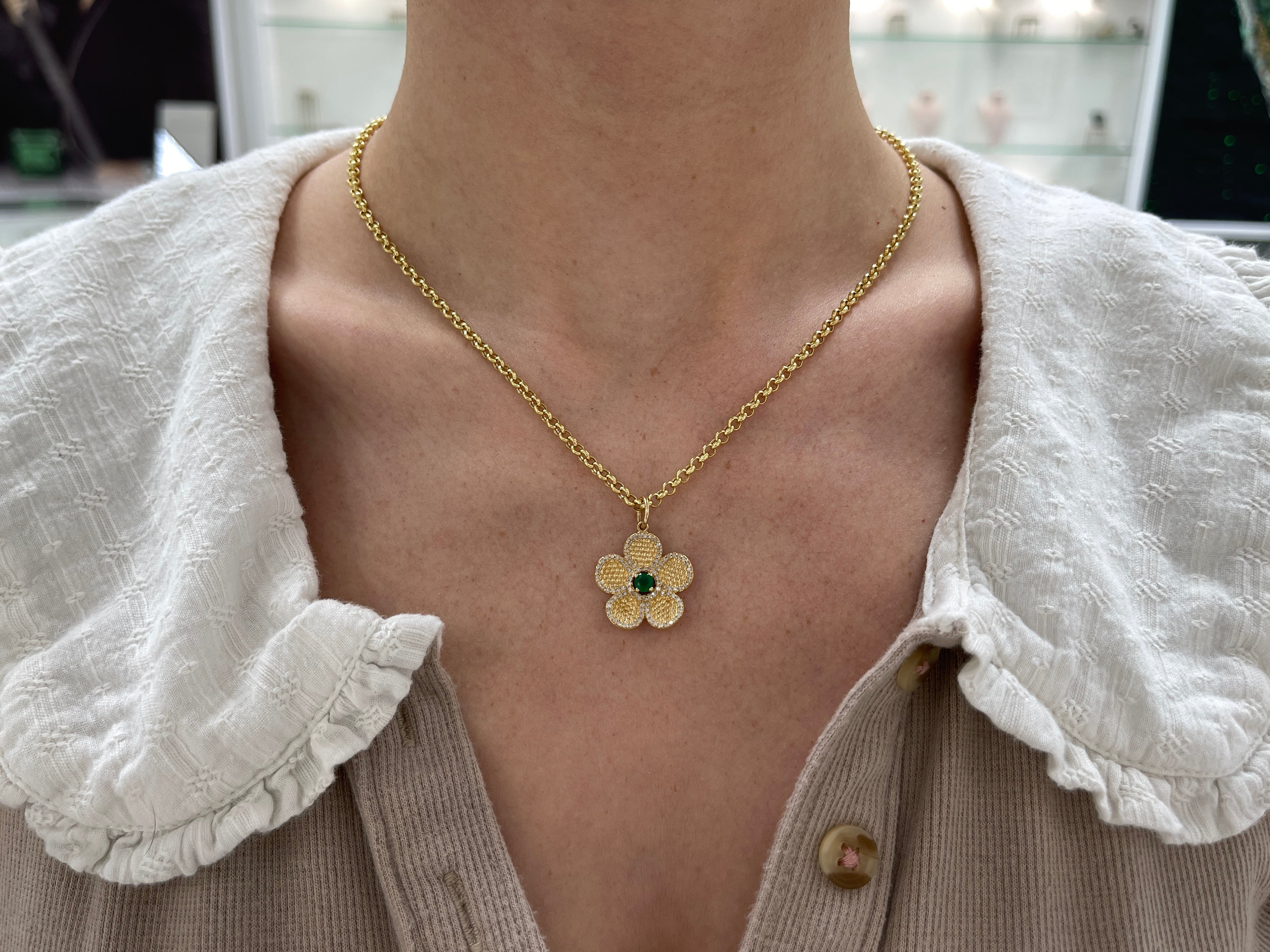 14K gold emerald and diamond flower pendant with 0.58 carats total weight, featuring vibrant green emeralds and sparkling diamonds.